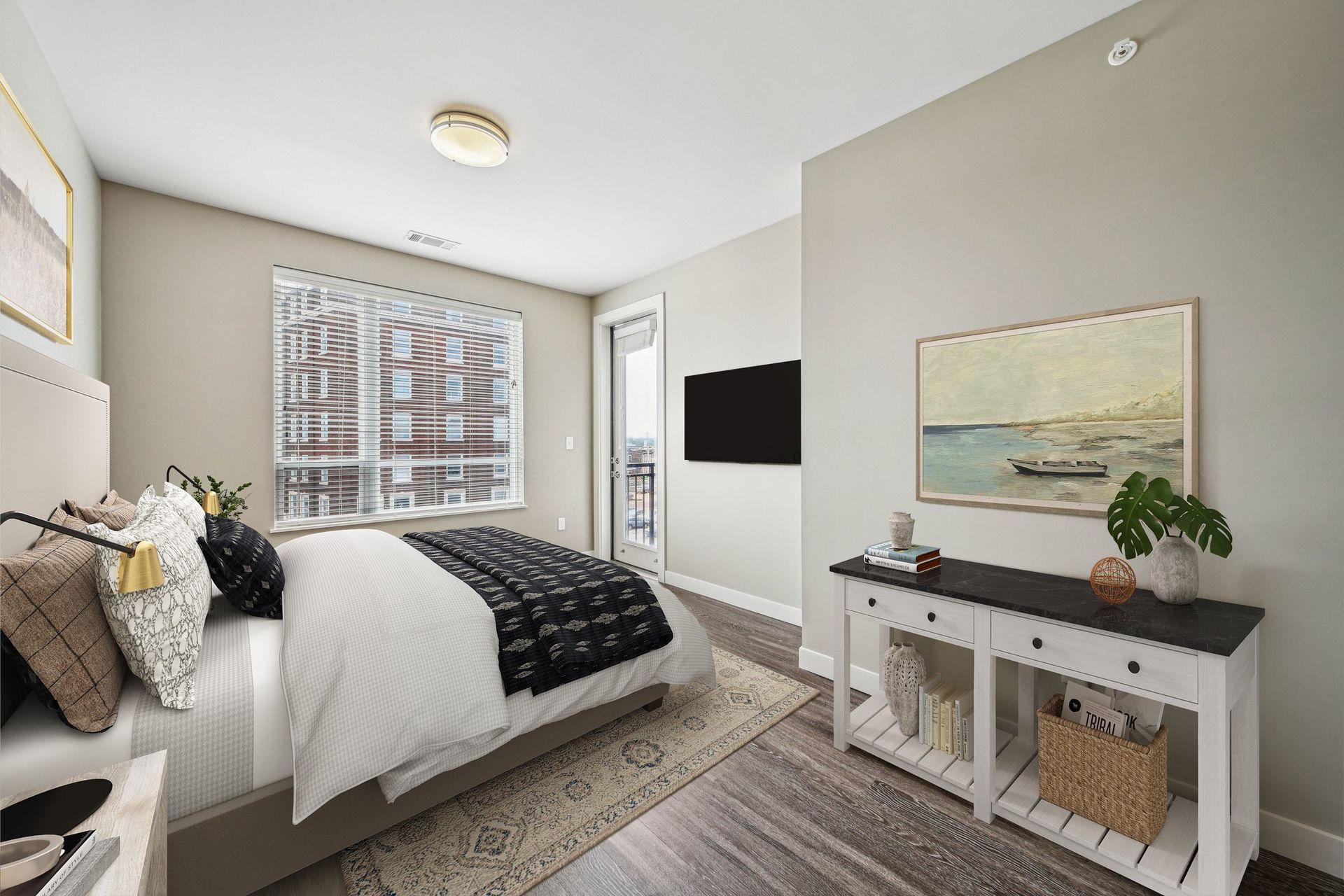 Bedroom in a modern apartment with bed, dresser, and balcony door.