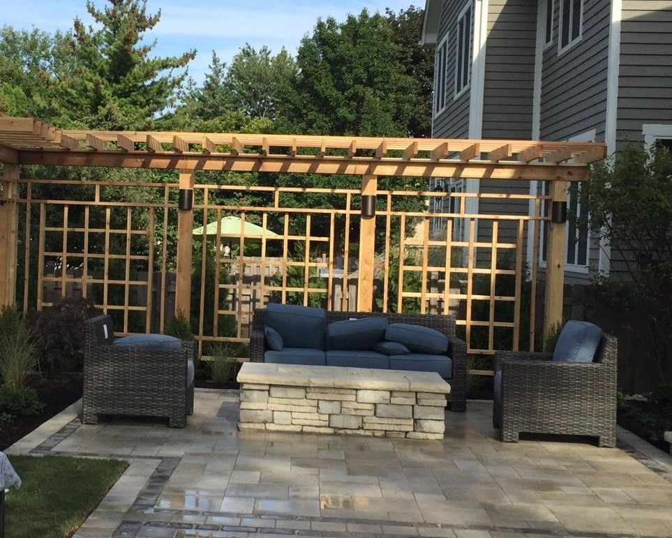 A patio with a couch and chairs under a pergola