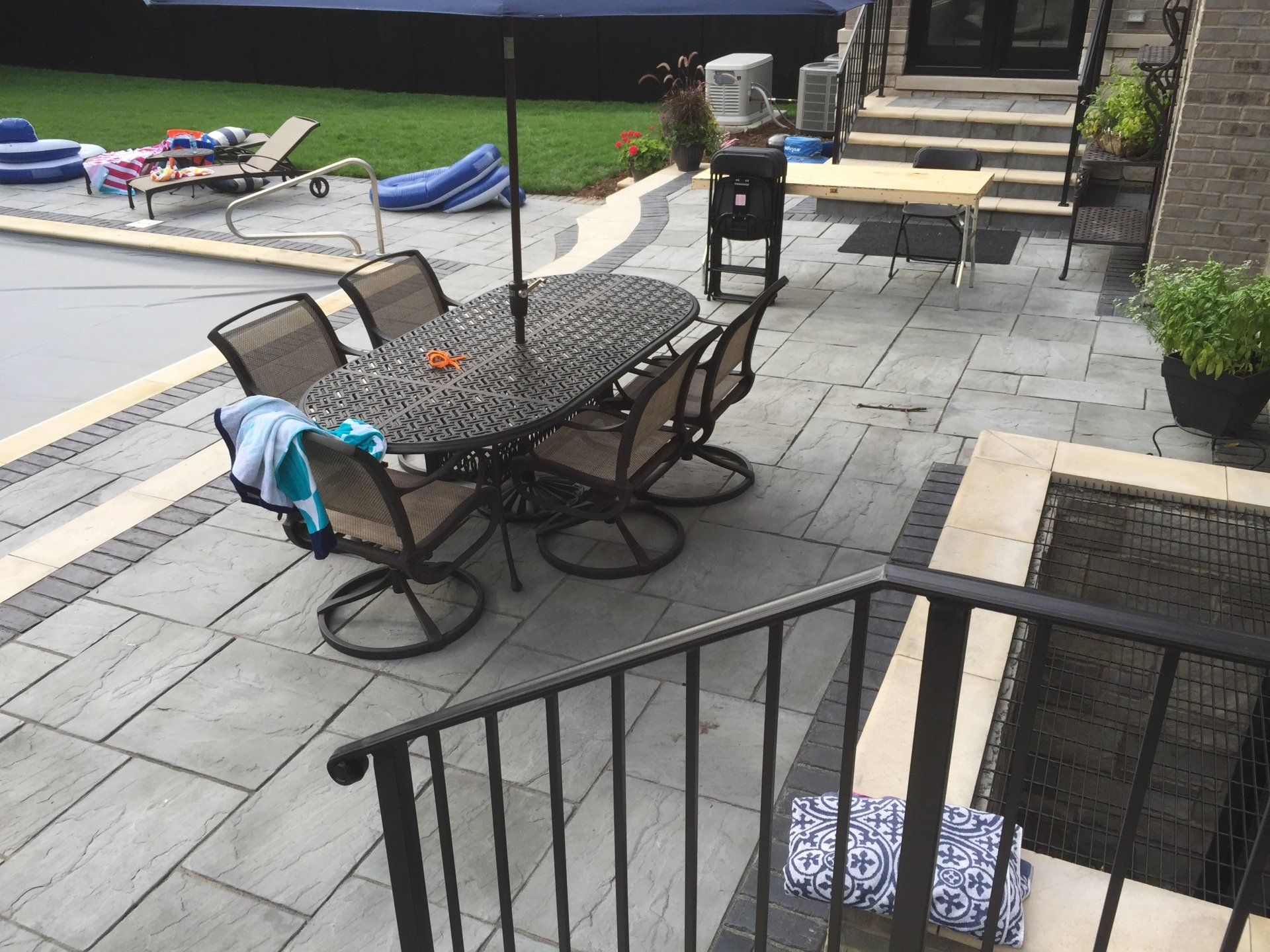 A patio with a table and chairs and an umbrella.