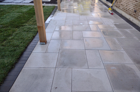 A brick walkway with a broom on the side of it