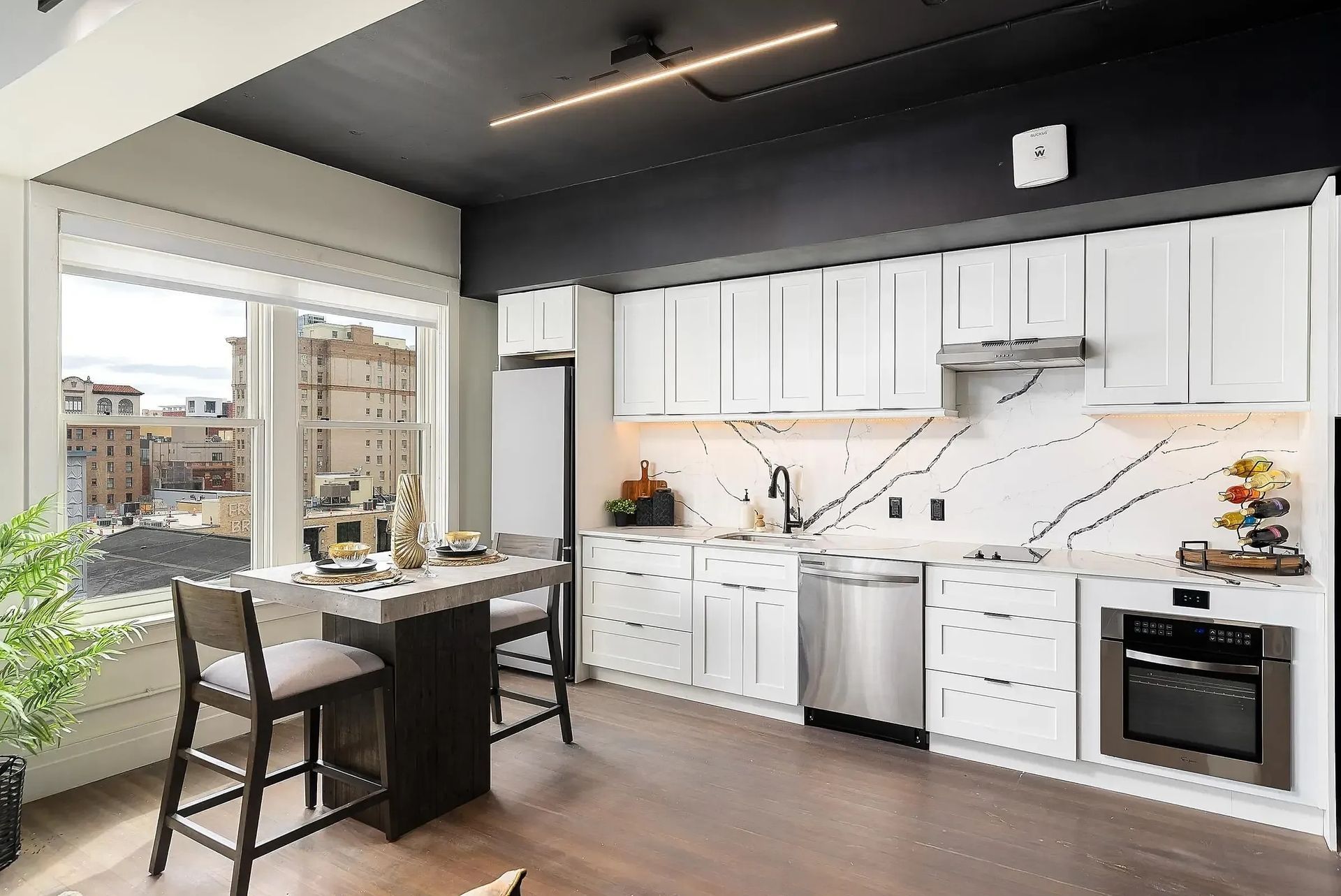 Modern kitchen with white cabinets, stainless steel appliances, and a dark gray ceiling.