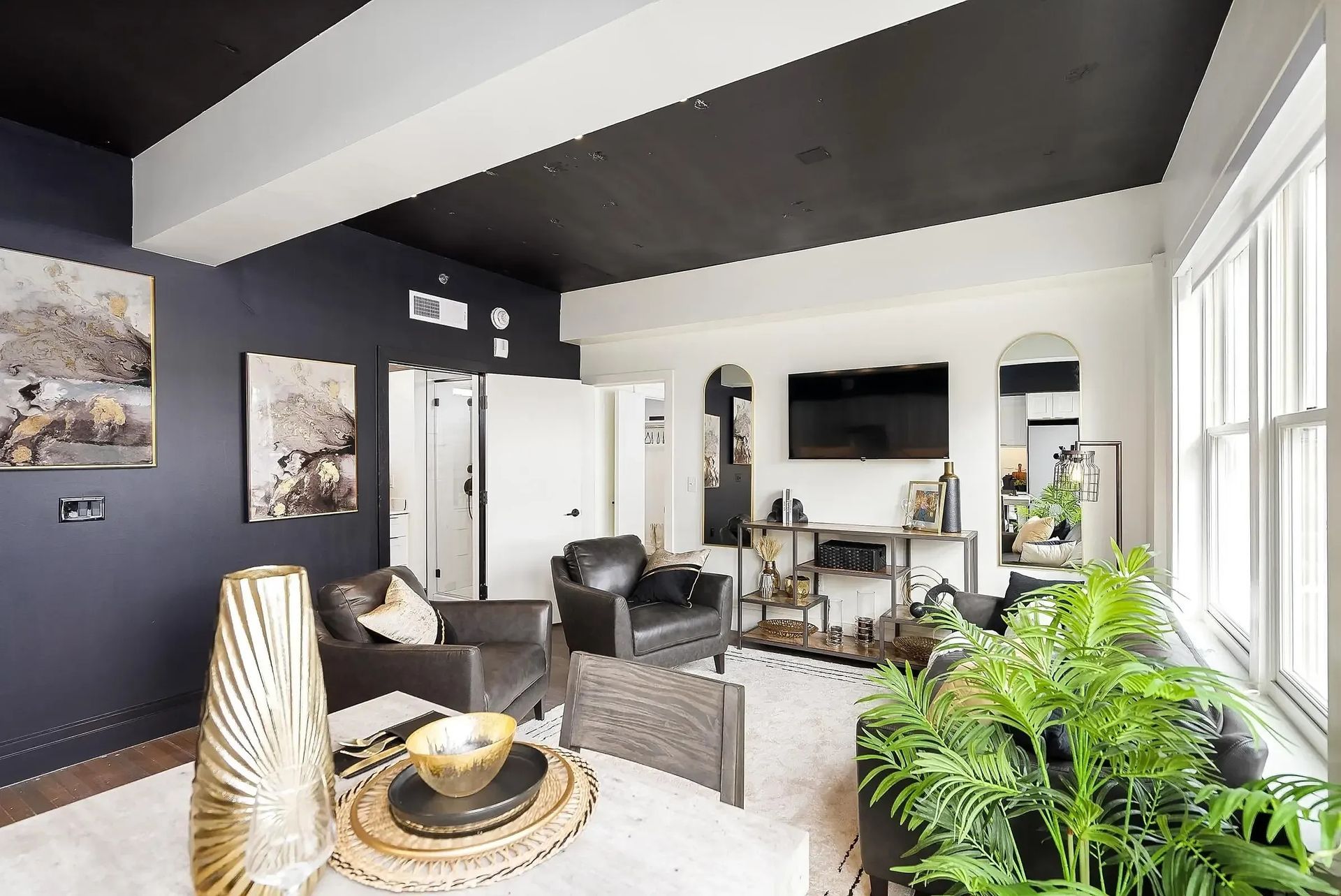 Living room with dark blue walls, black ceiling, white trim, and modern furniture.