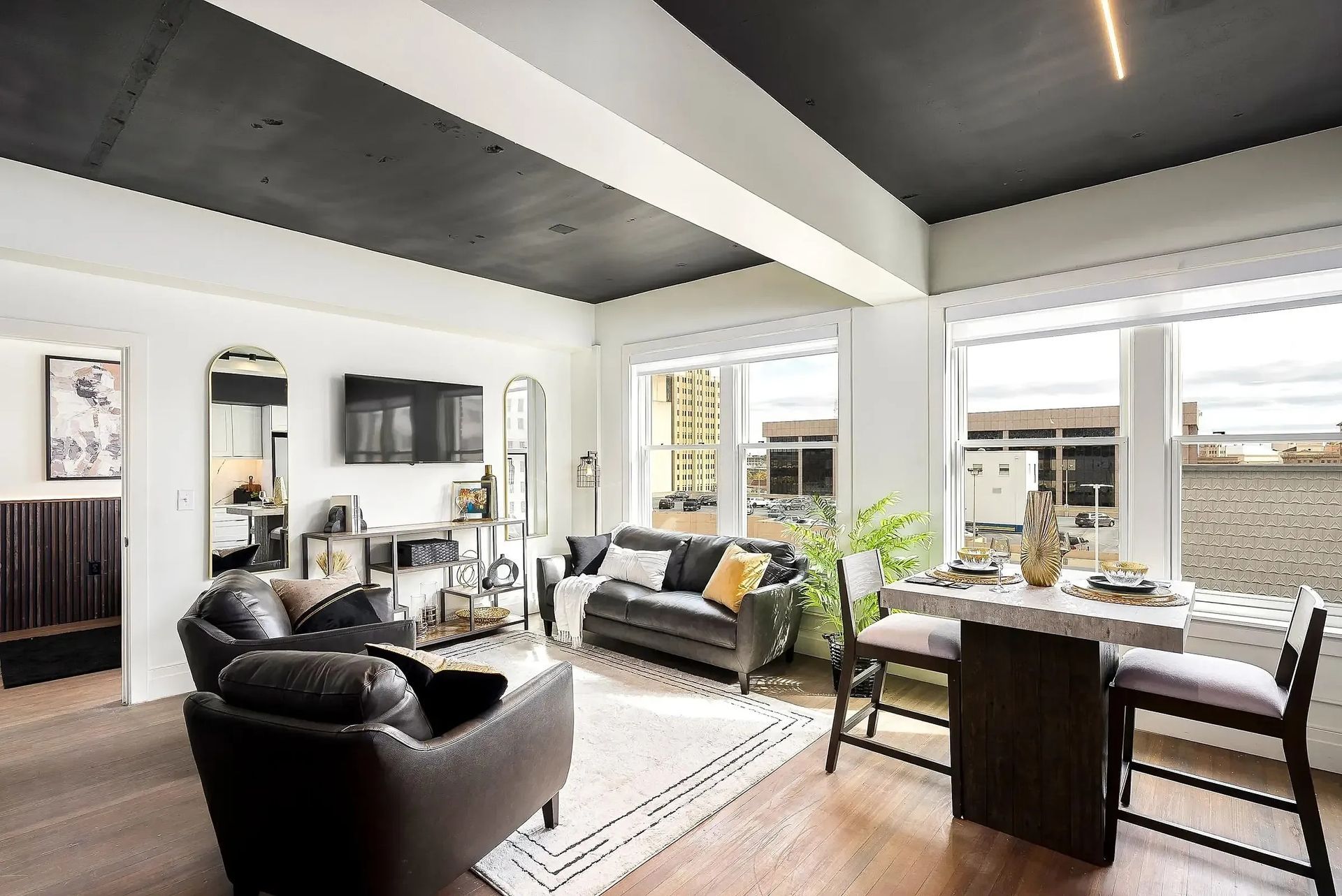 Stylish living room with black ceiling, leather furniture, and a marble-topped table.