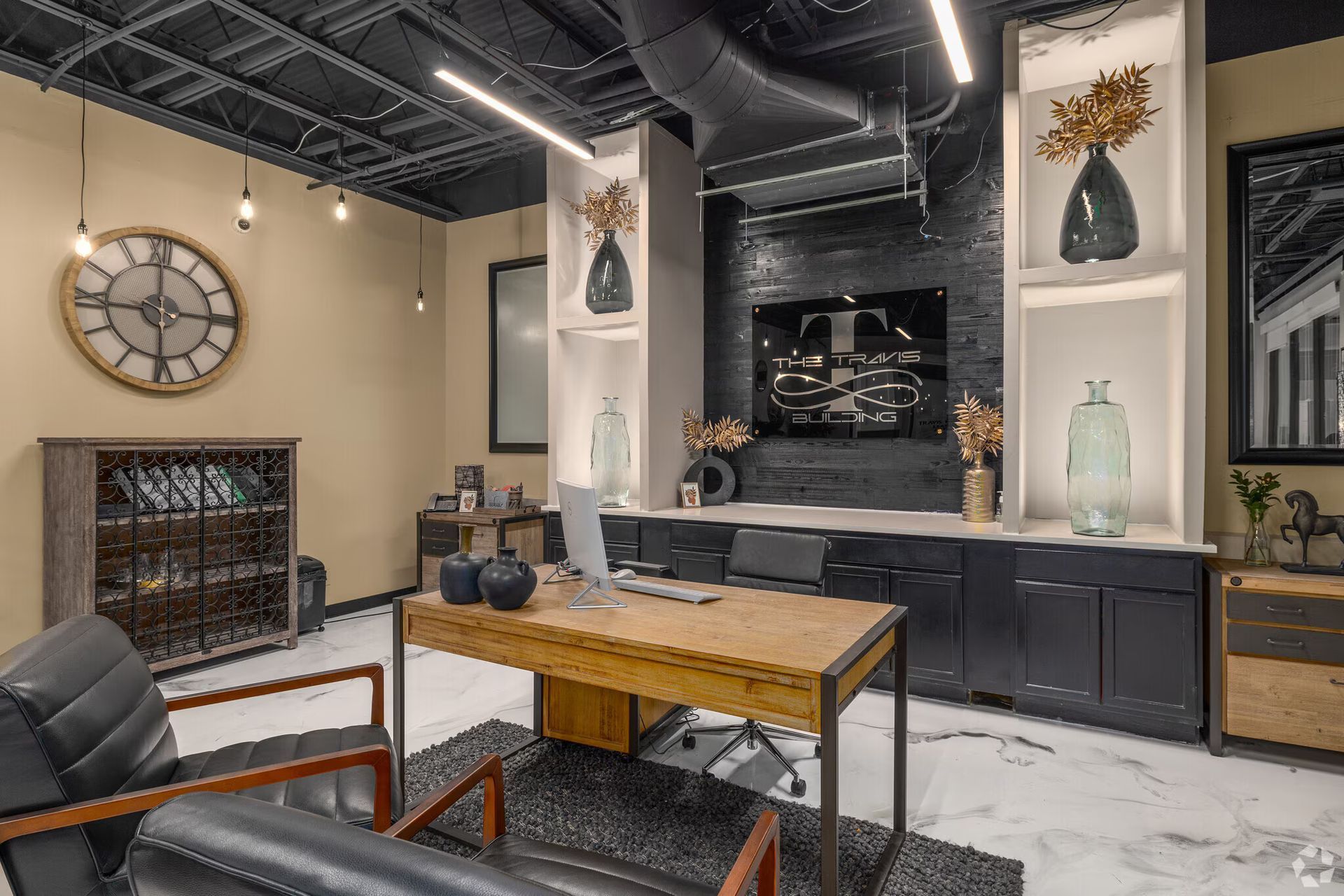 Modern office with black and wood accents, desk, seating, and large clock.