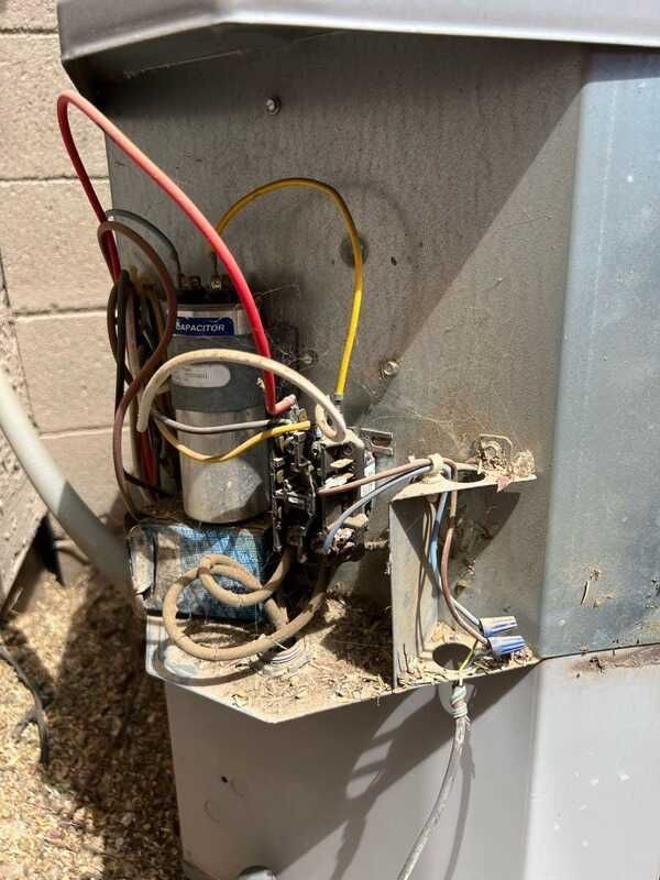 Air conditioning units with toolbox and gloves in backyard.