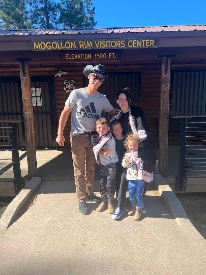 Man using remote control to operate air conditioner, white wall, window.