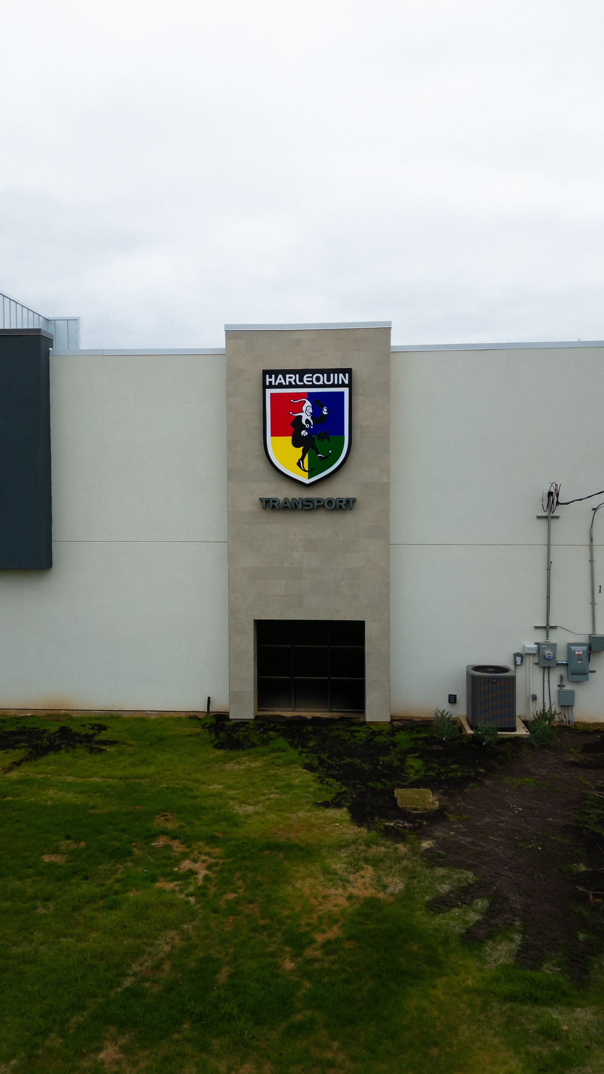 The side of the Harlequin Transport offices in Laredo. The side sign is the logo for the freight forwarding company. 