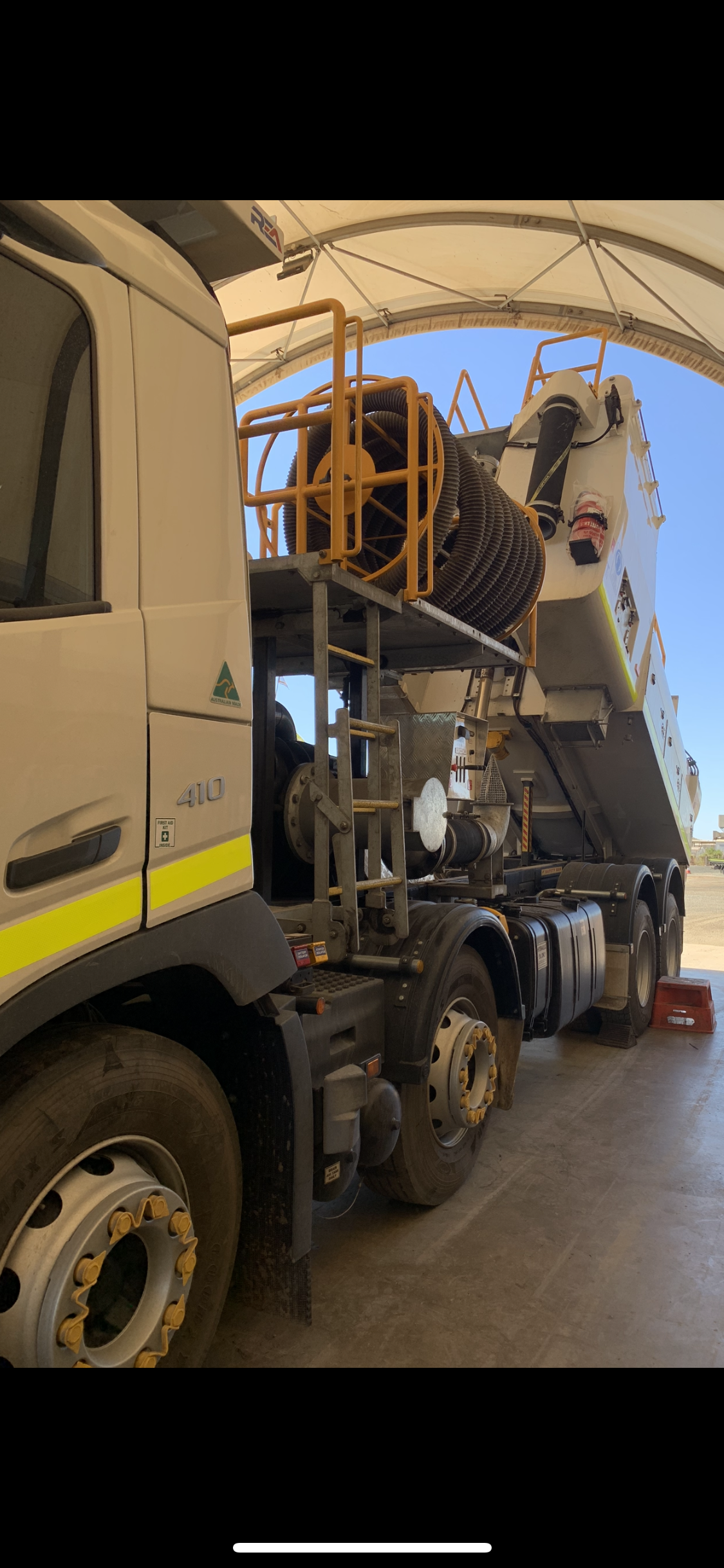 Side view of a large truck with a ladder and equipment rack under a tent roof. — Bodes All Mechanical In Eden, NSW