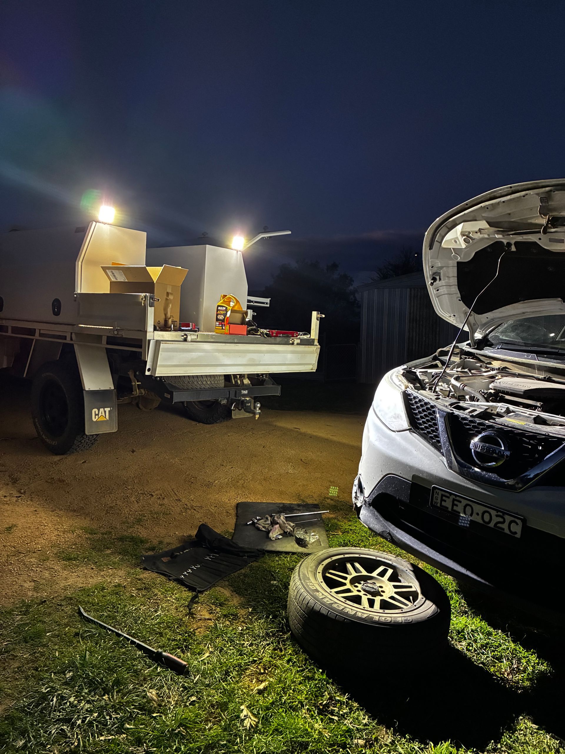 Car being worked on at night with tow truck and lights. Flat tire, hood open. — Bodes All Mechanical In Bombala, NSW