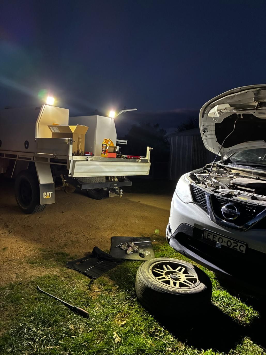 Car Being Repaired at Night Next to a Service Truck — Bodes All Mechanical In Bega, NSW