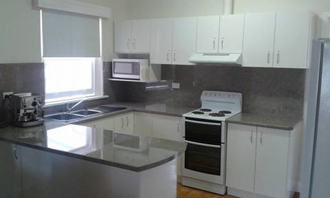 View of kitchen cabinets with counter tops