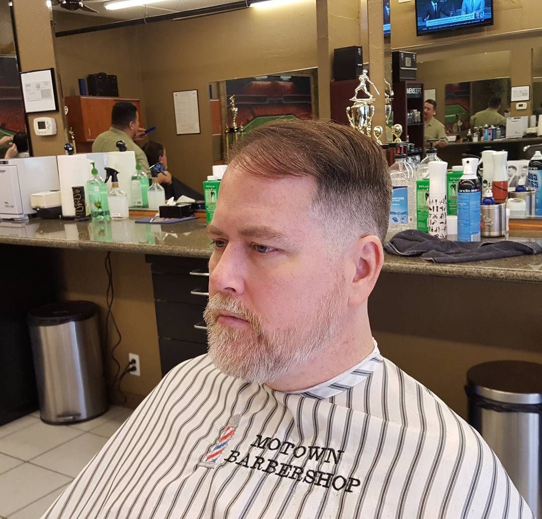 A man is getting his hair cut at a barber shop