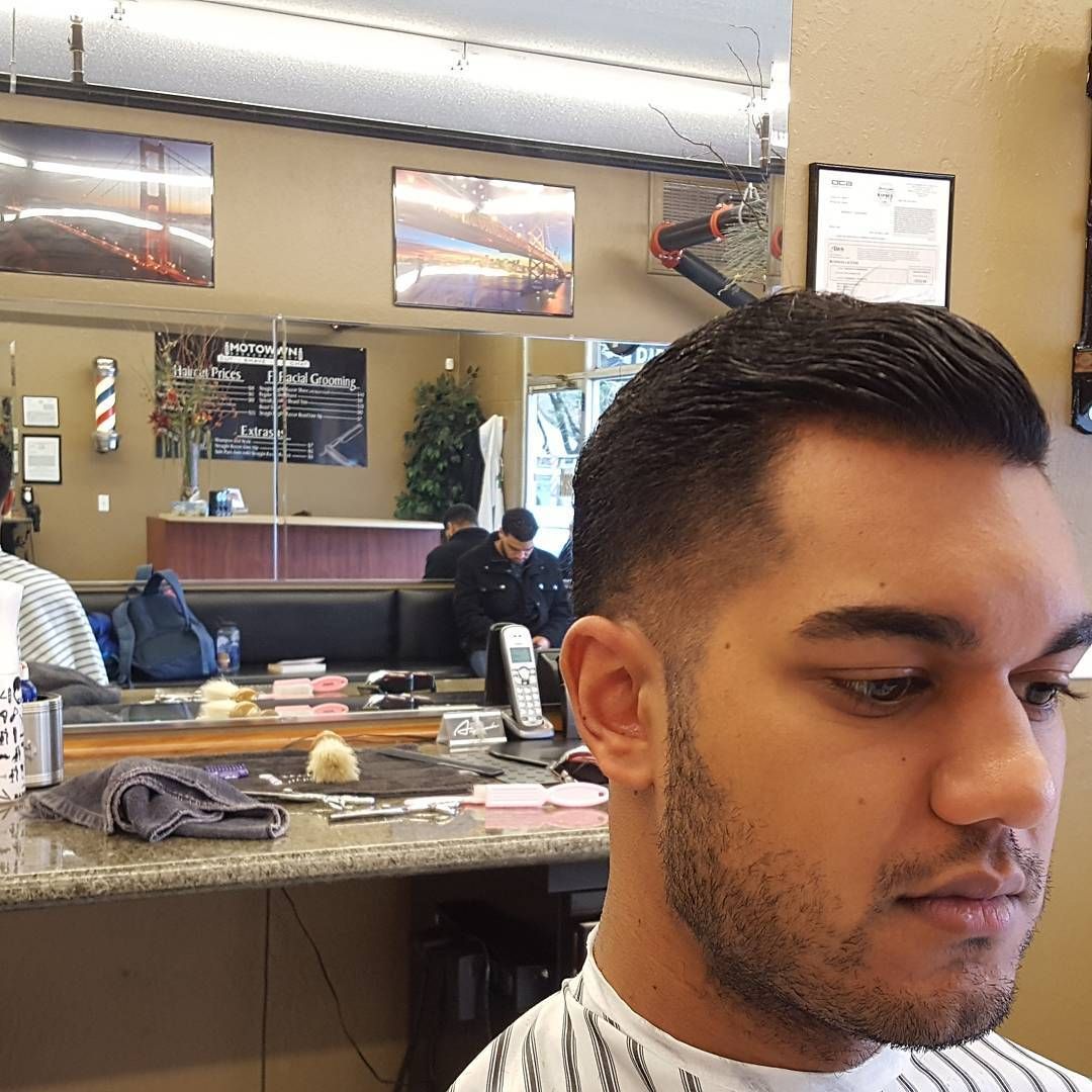 A man is getting his hair cut at a barber shop