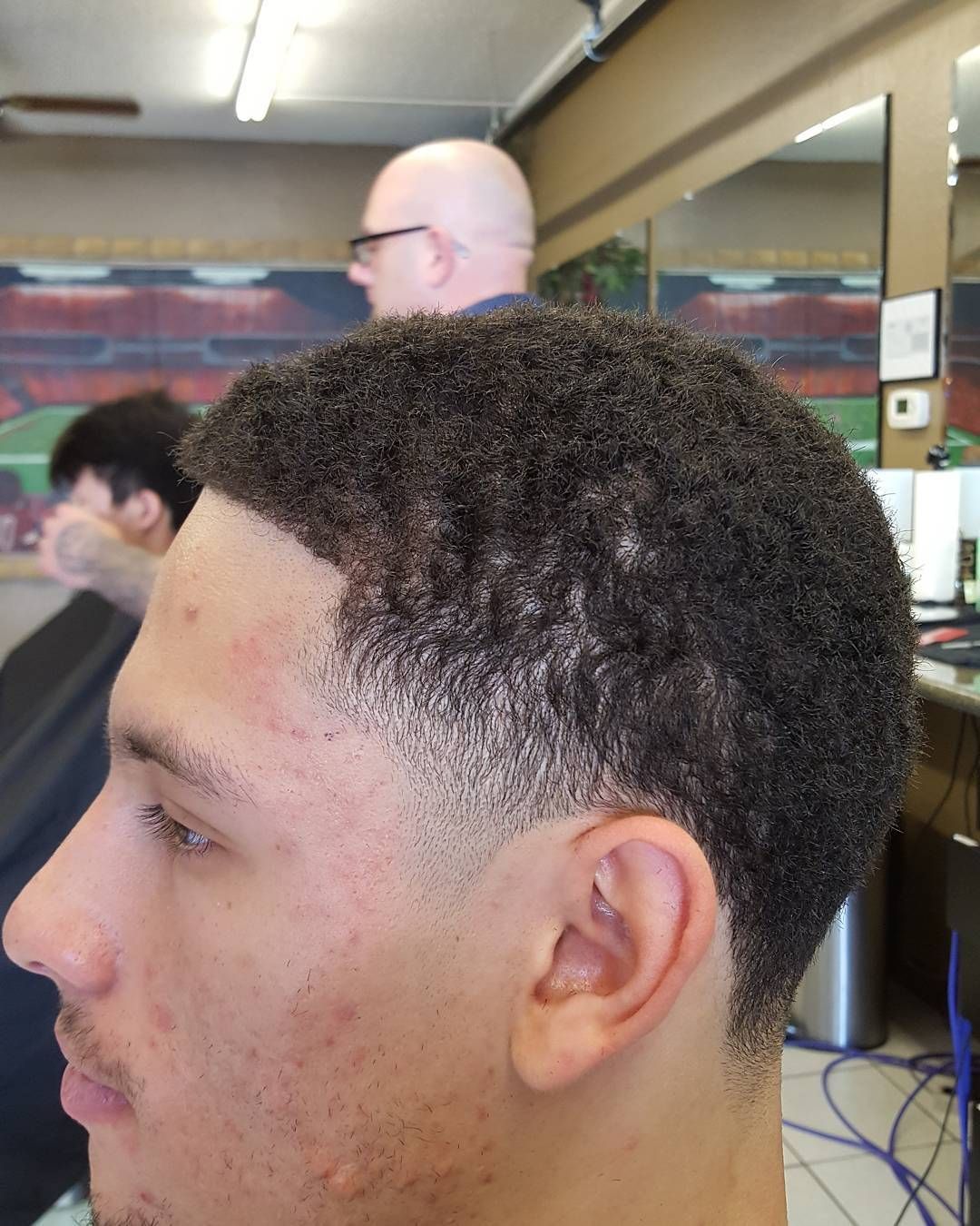 A man is getting his hair cut at a barber shop