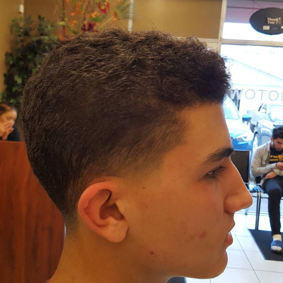 A close up of a man 's head with a very short haircut