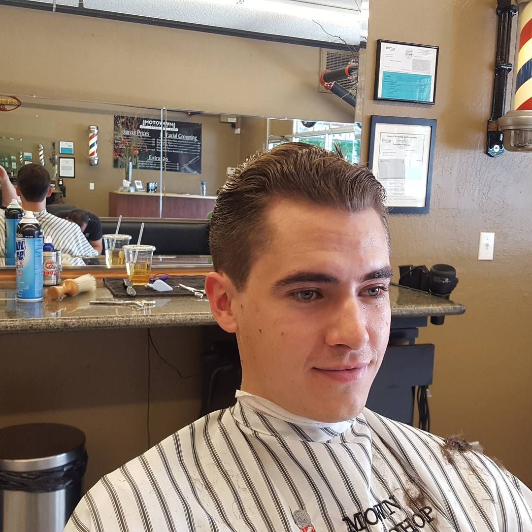 A man is getting his hair cut at a barber shop