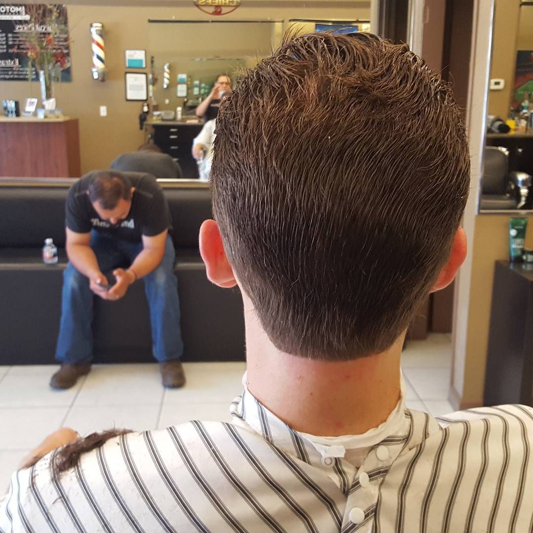 A man is getting his hair cut at a barber shop