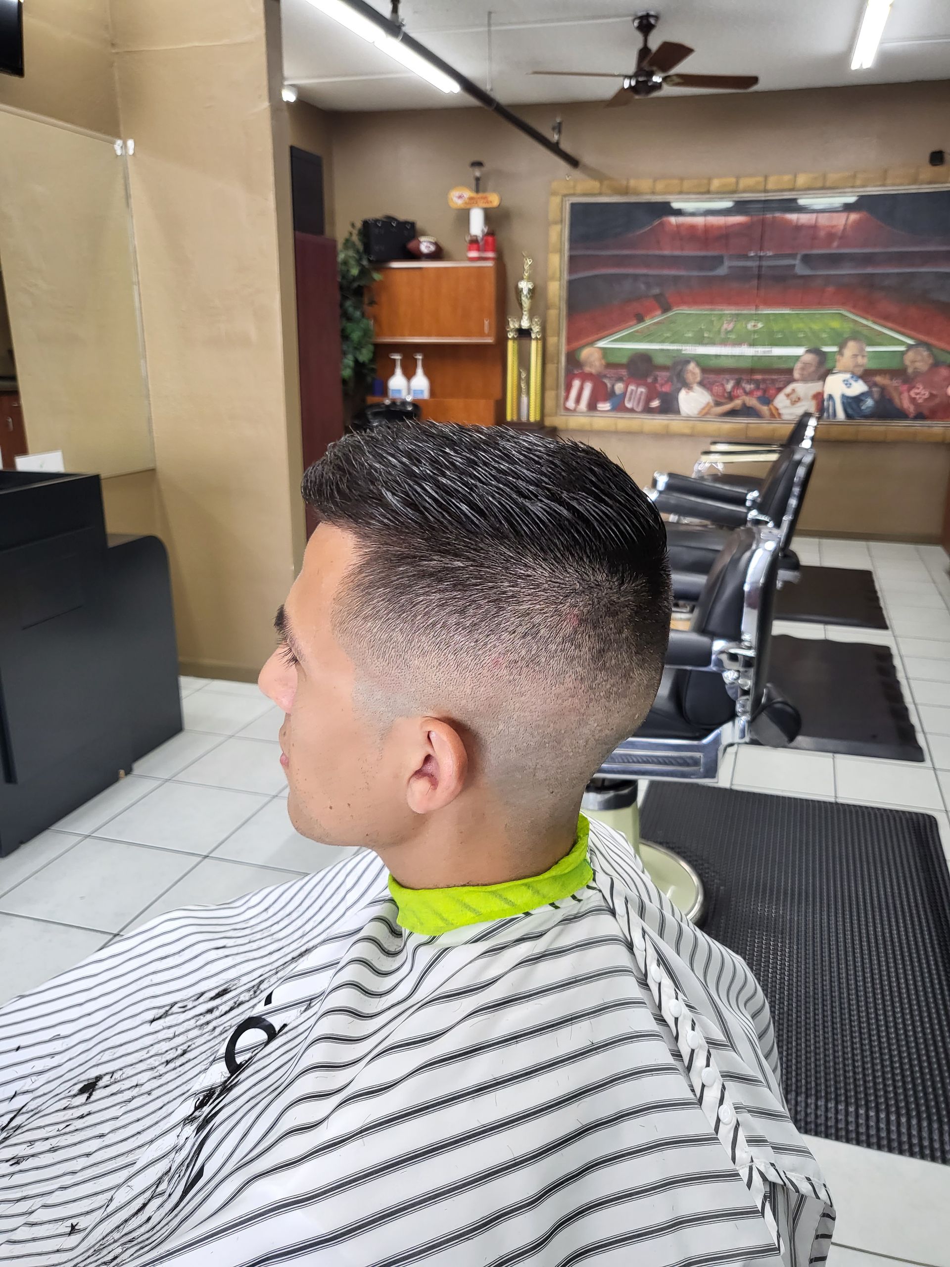 A man is getting his hair cut at a barber shop