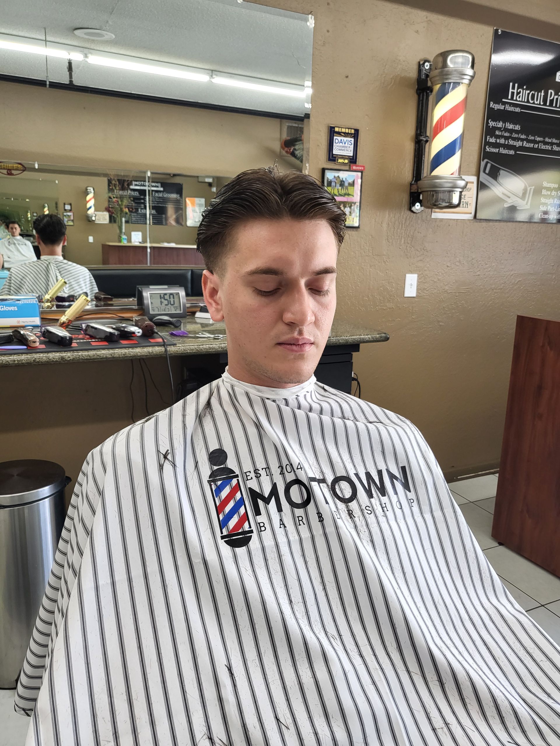 A man is getting his hair cut at a barber shop