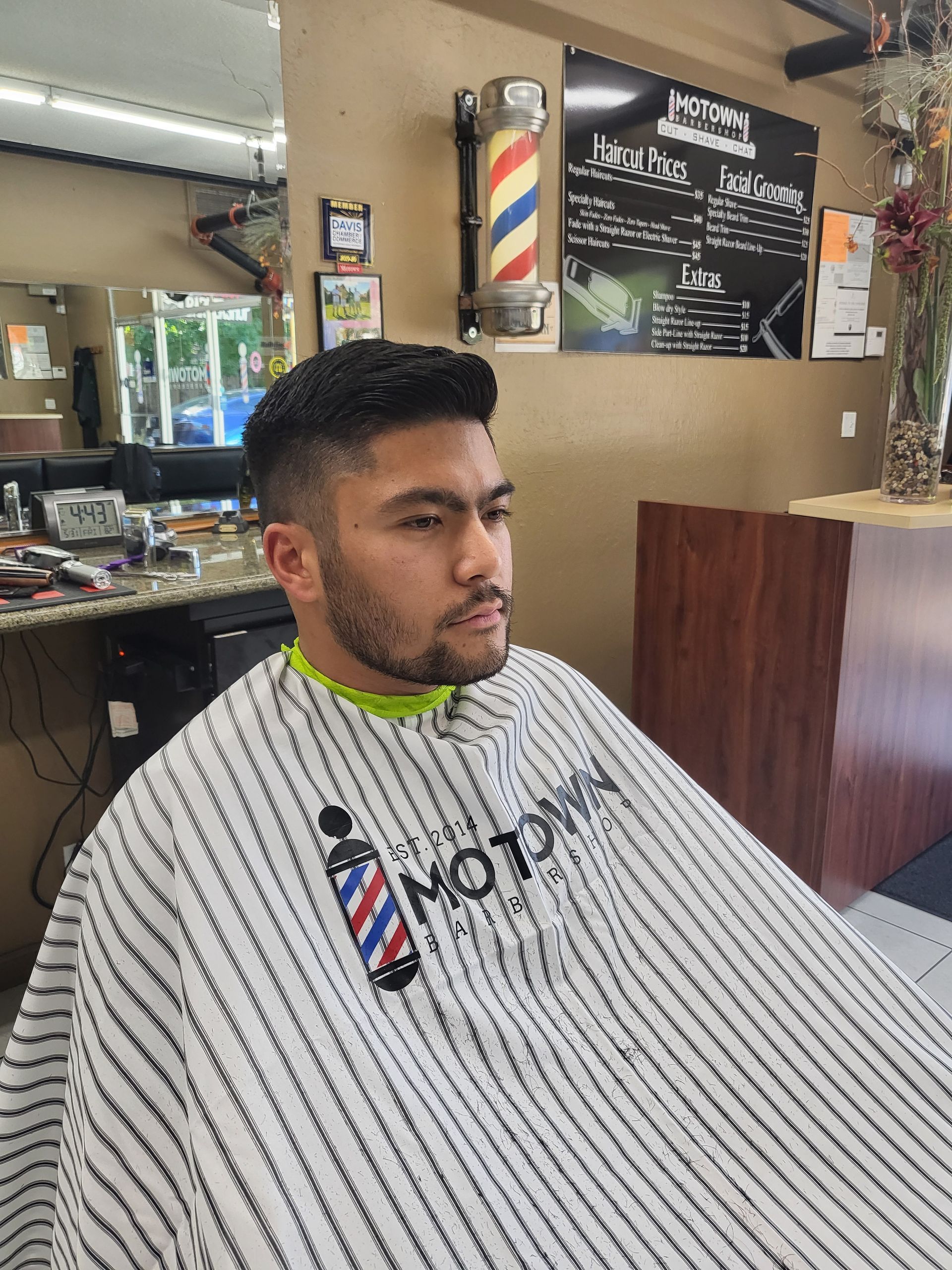A man is getting his hair cut at a barber shop