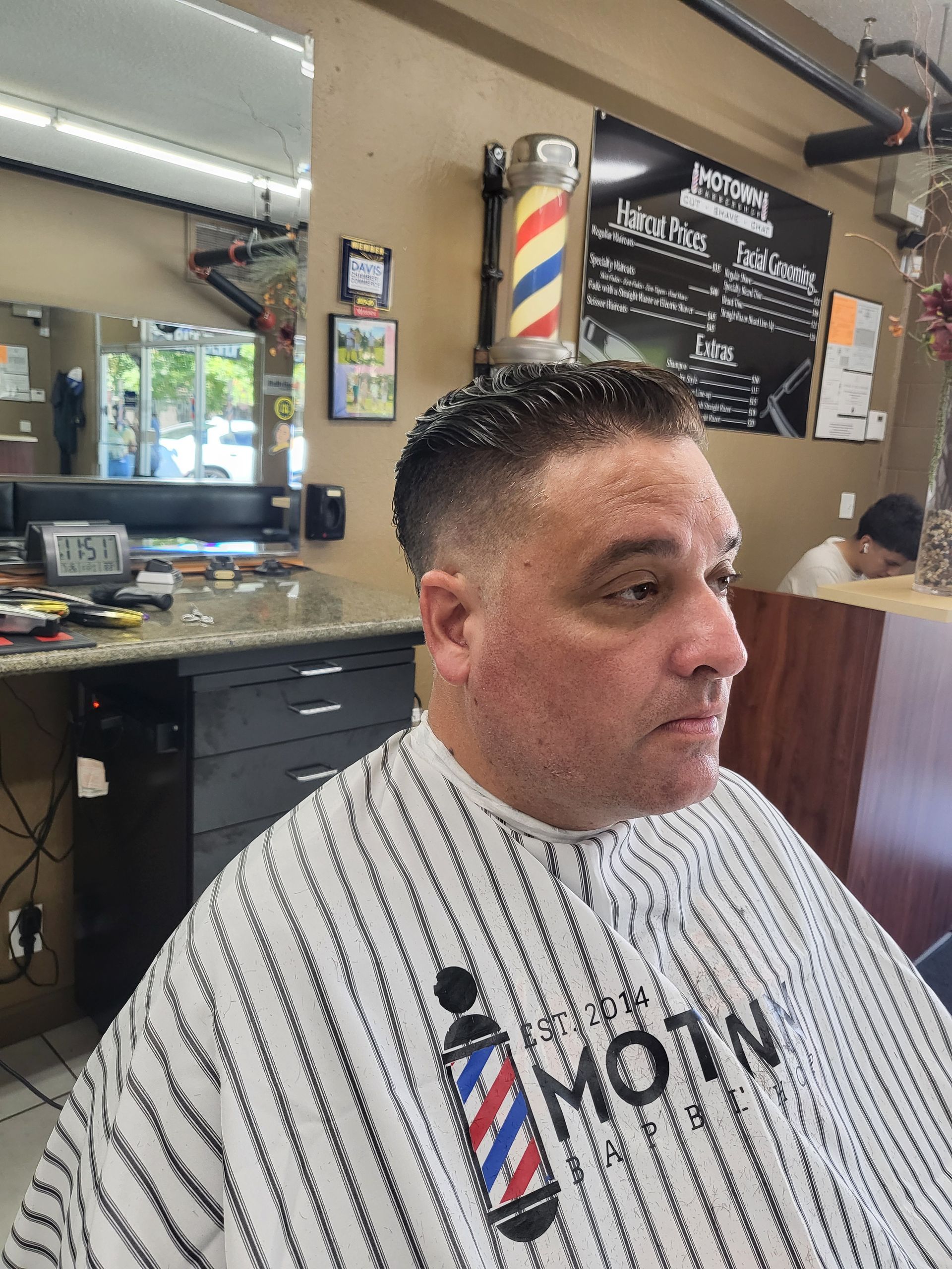 A man is getting his hair cut at a barber shop
