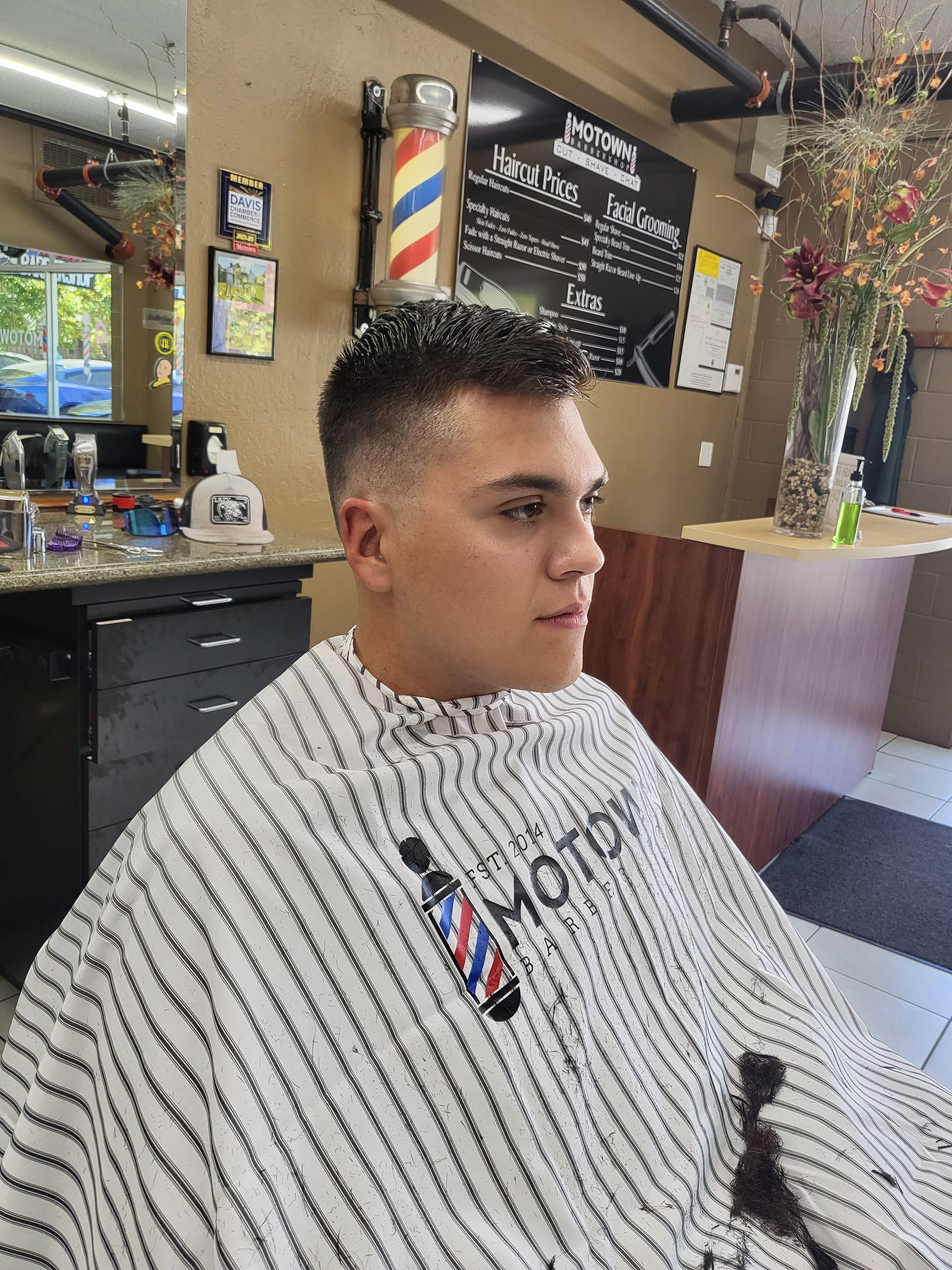 A man is getting his hair cut at a barber shop.