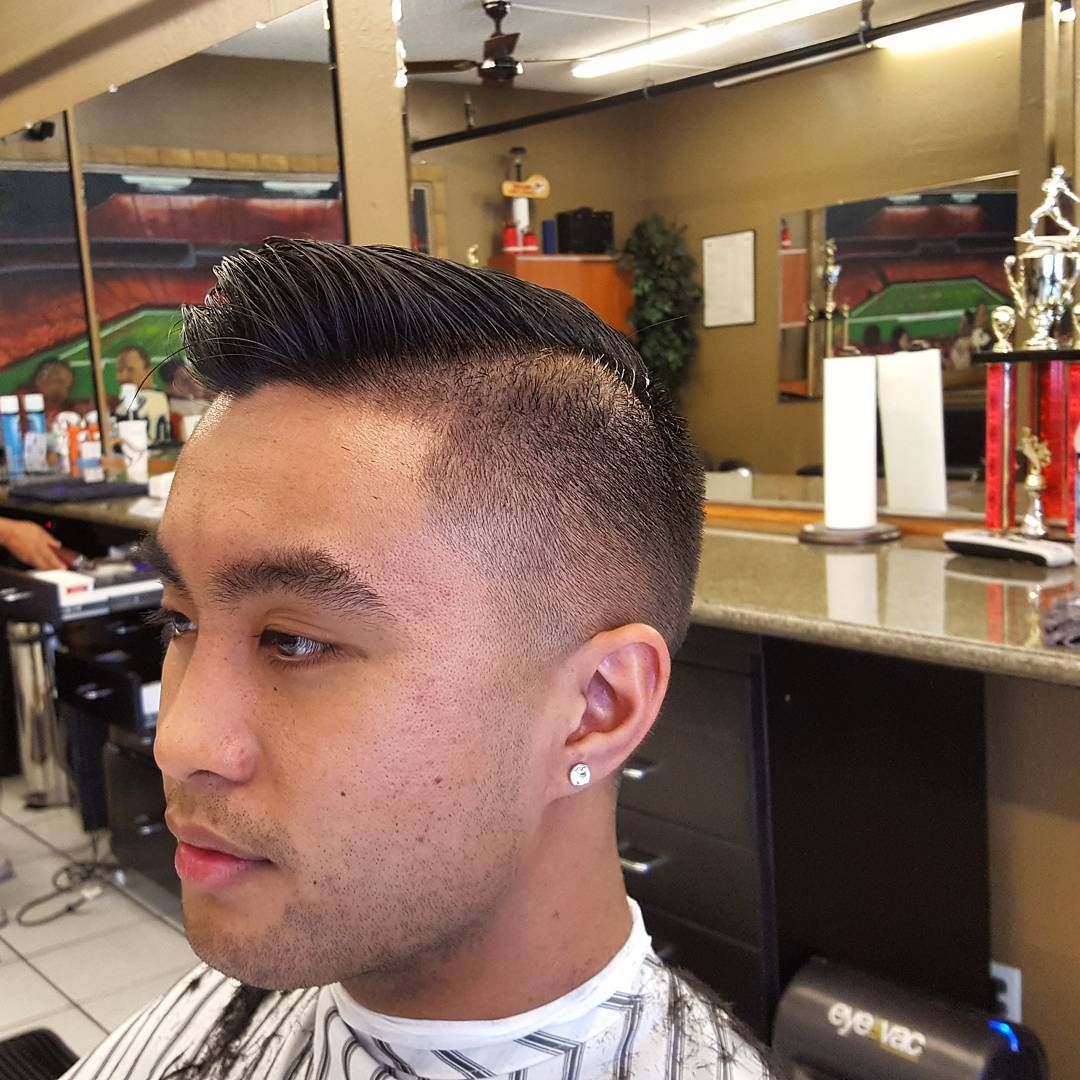 A man is getting his hair cut at a barber shop
