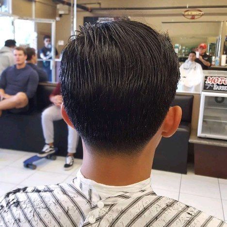 A man is getting his hair cut at a barber shop