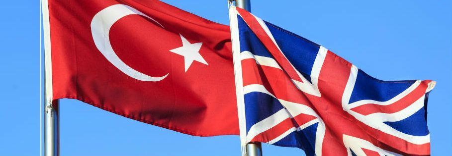 A picture of a Turkish and British flag side by side