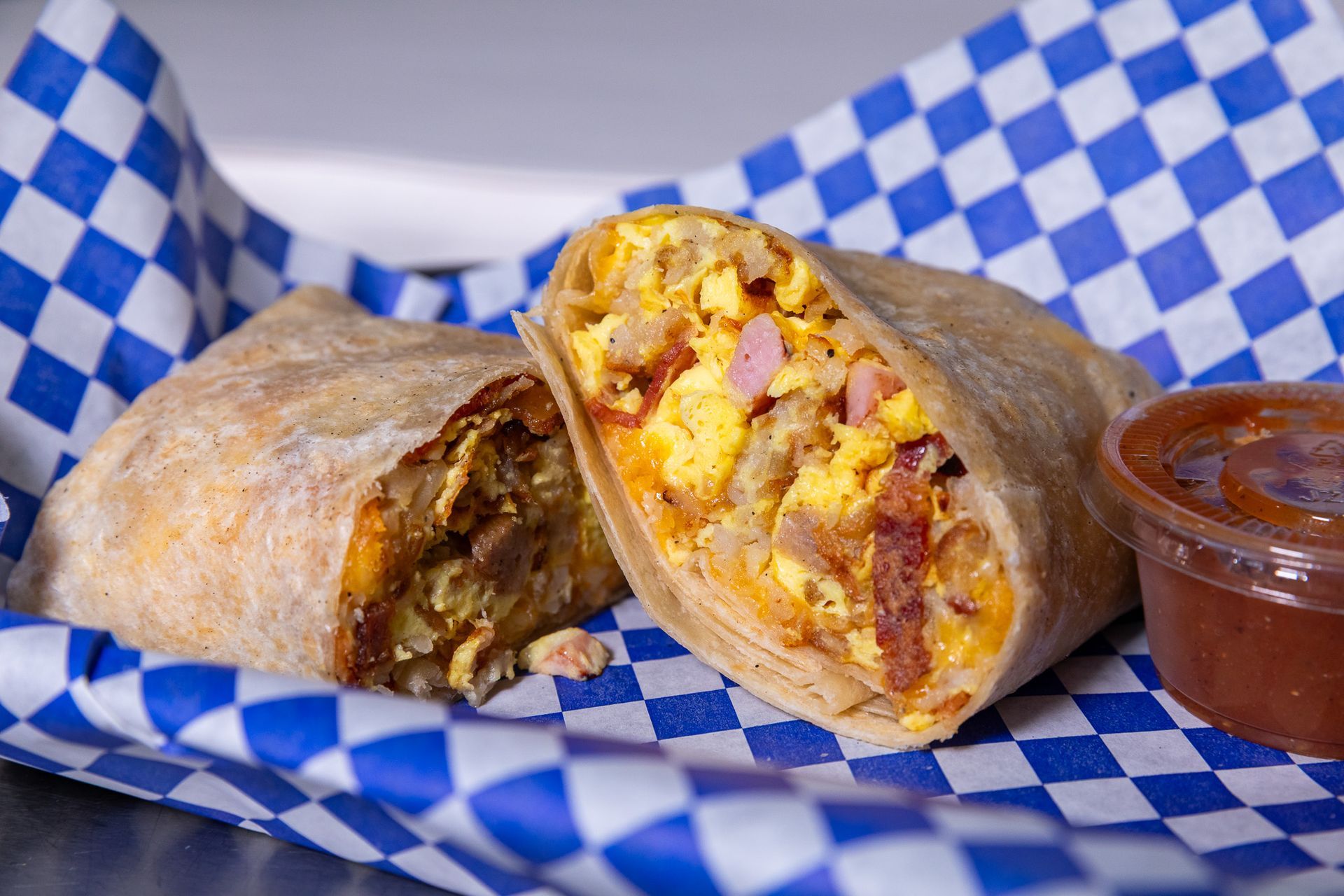 Avocado toast topped with egg, cucumber, tomatoes, and feta, being drizzled with balsamic vinaigrette.