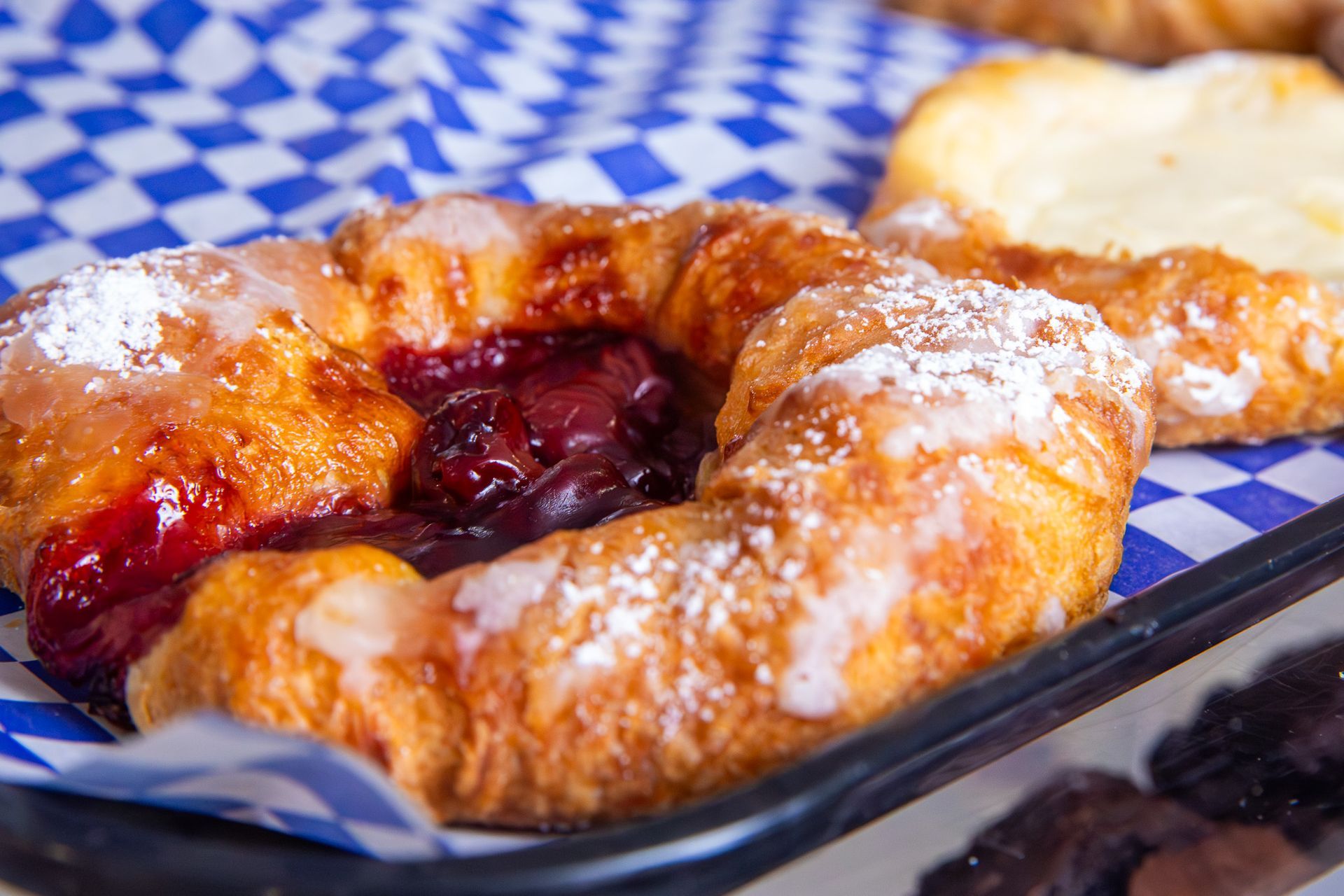 Avocado toast topped with egg, cucumber, tomatoes, and feta, being drizzled with balsamic vinaigrette.