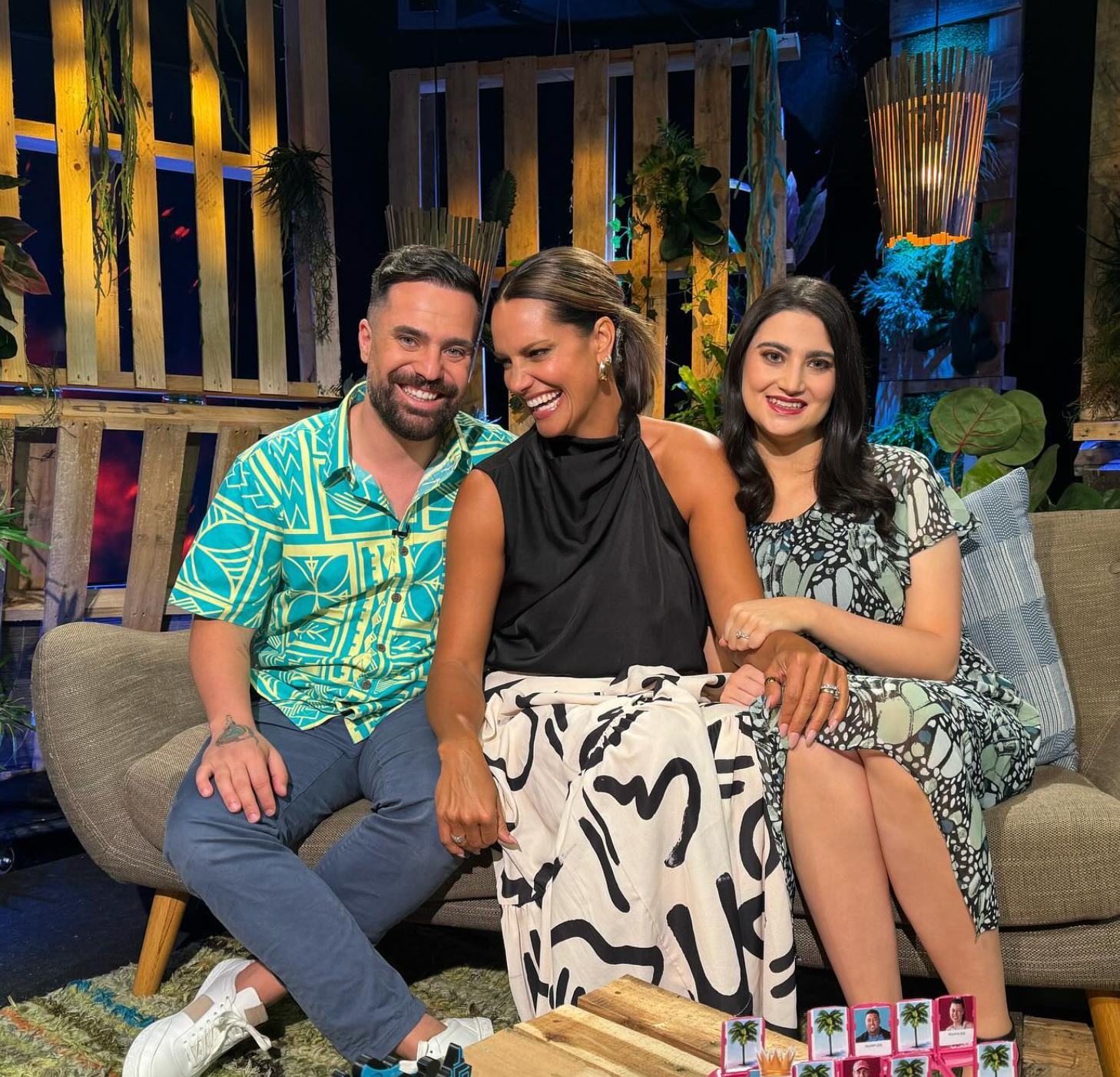 A man and two women are sitting on a couch.