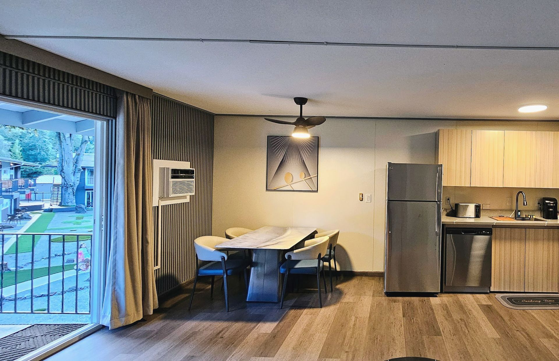 A living room with a table and chairs and a refrigerator