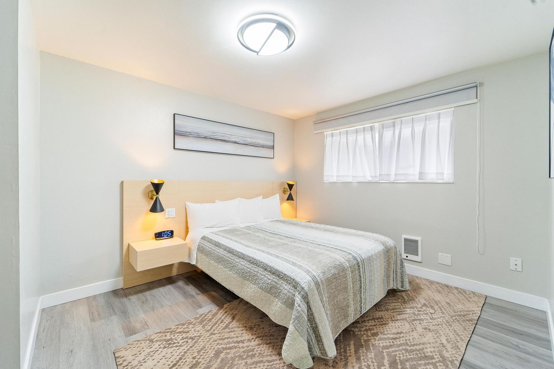 A bedroom with a large bed and a window.