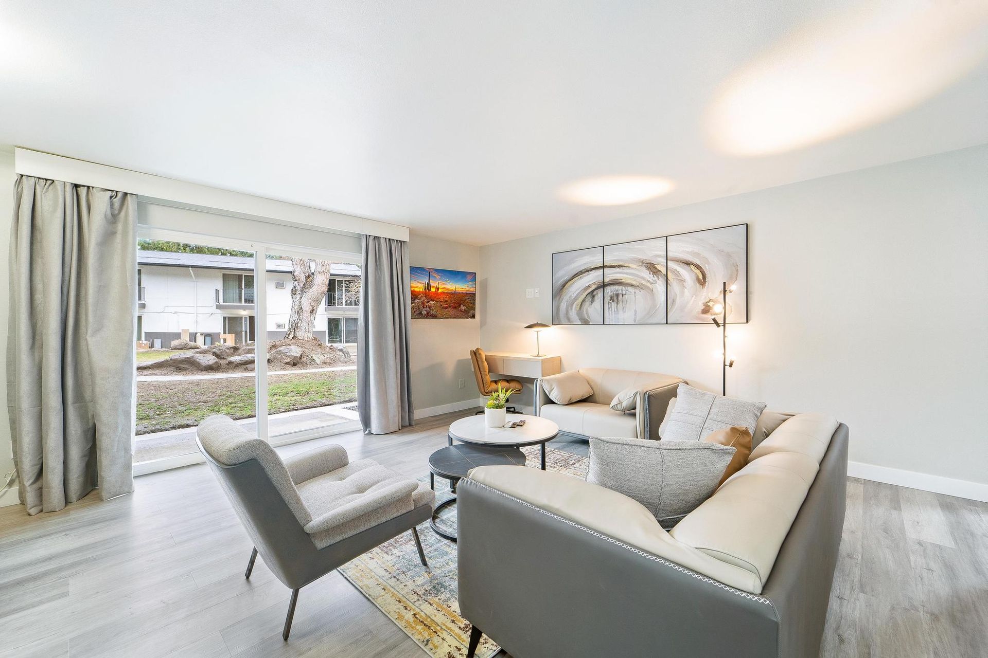 A living room with a couch , chairs , and a table.