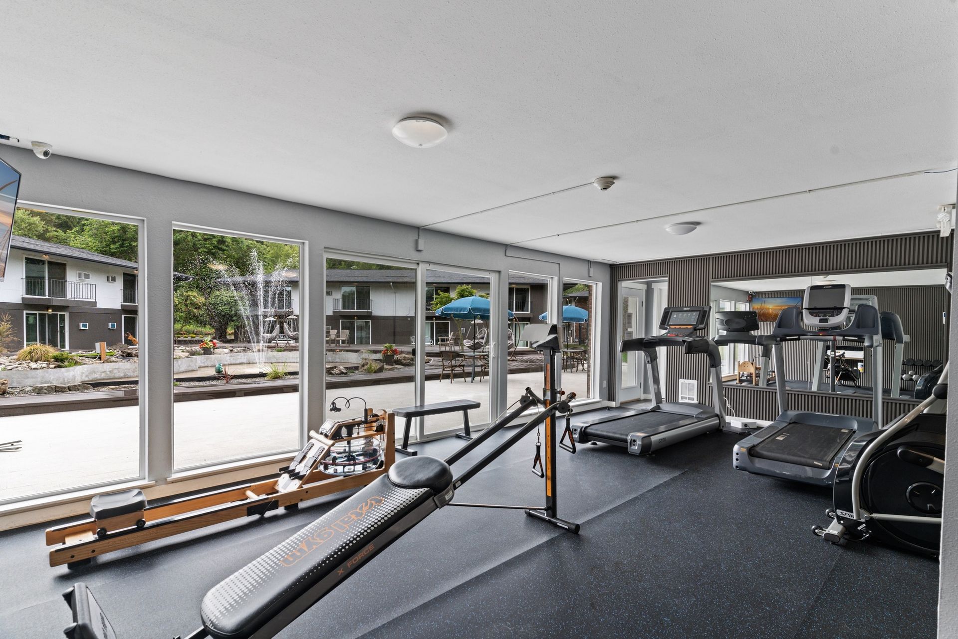 A gym with treadmills and a rowing machine