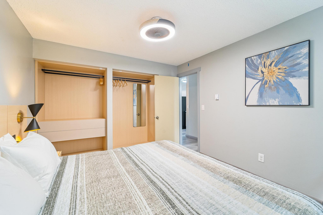 A bedroom with a bed , nightstand , and window.