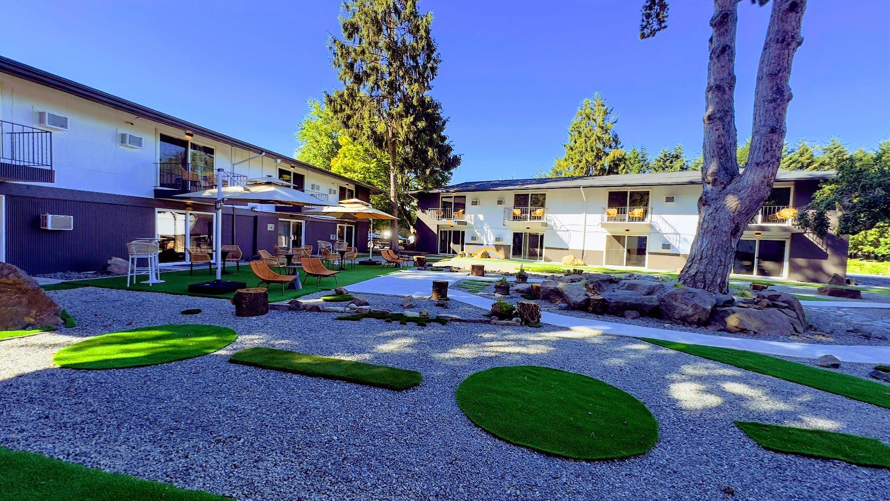 A large house with a lot of grass and rocks in front of it.