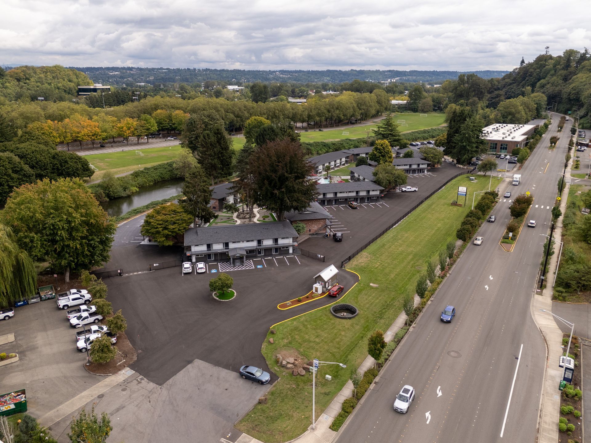 An aerial view of a parking lot next to a road.