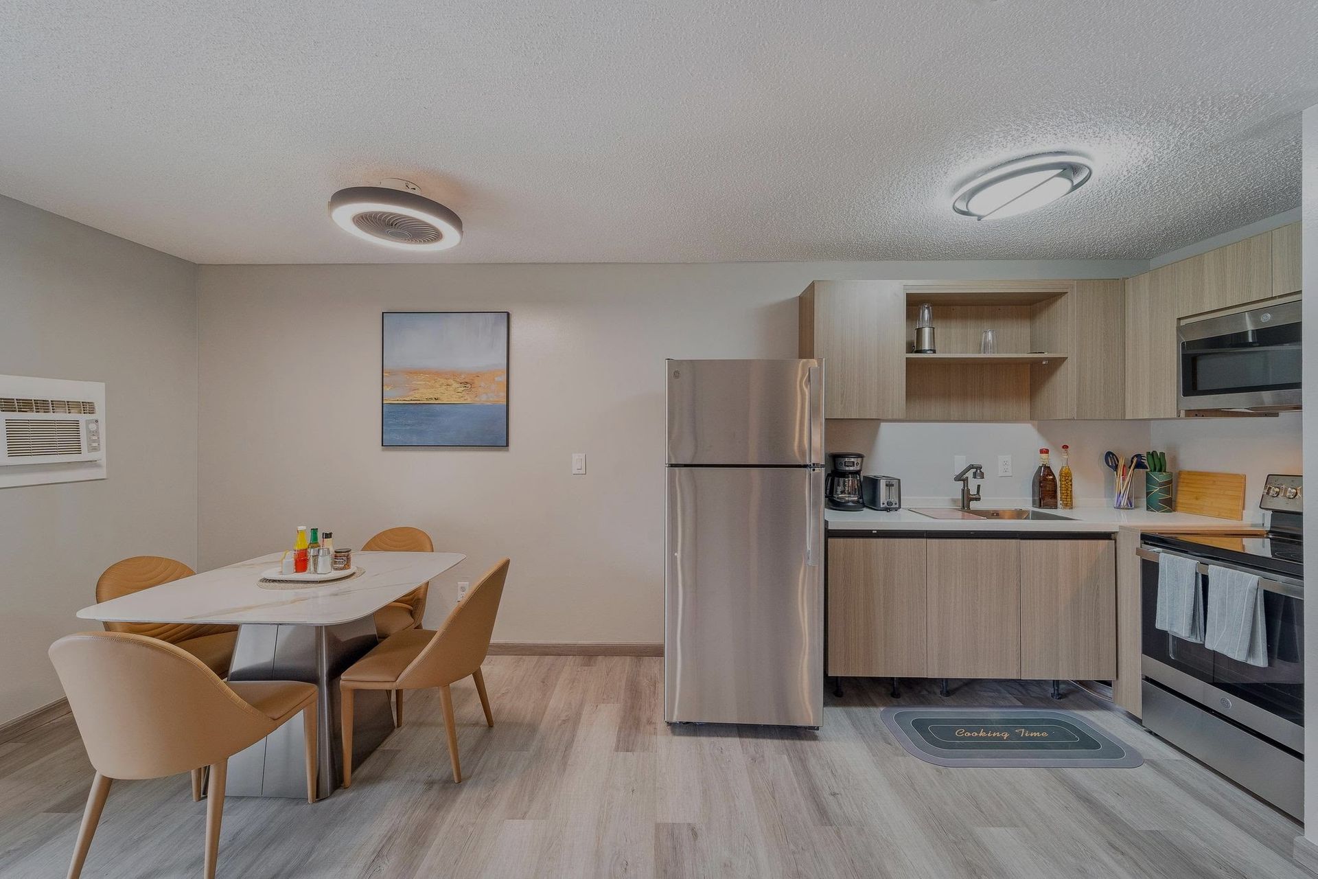 A kitchen with a table and chairs and a refrigerator.