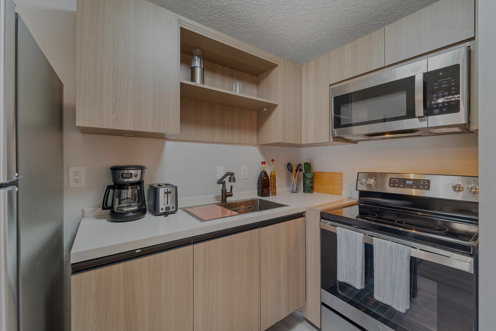 A kitchen with stainless steel appliances and wooden cabinets.