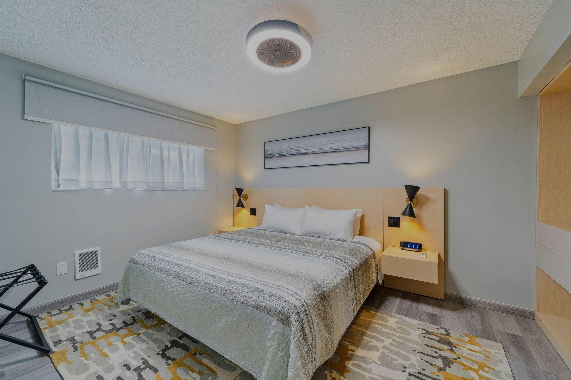 A hotel room with a king size bed and a rug.