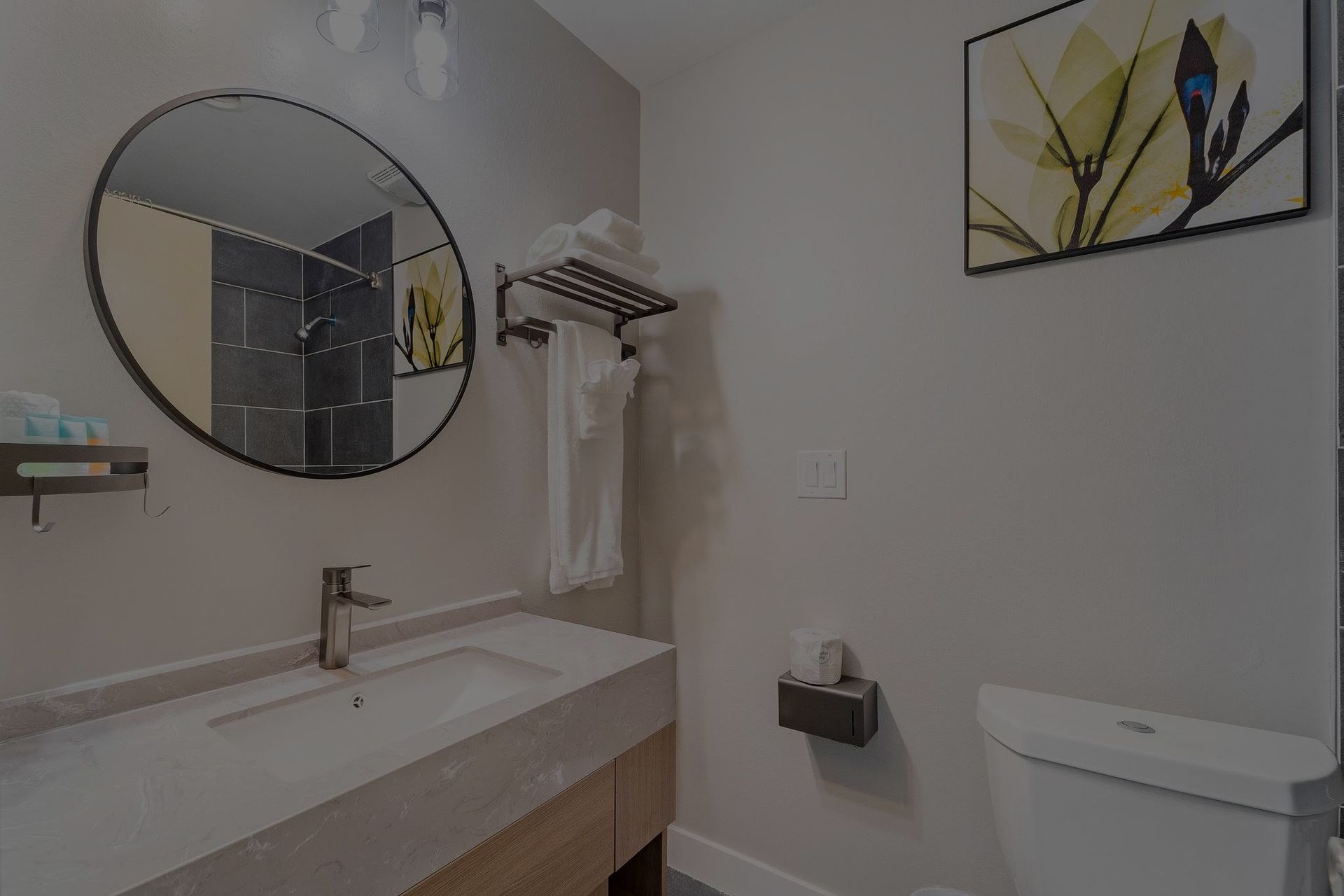 A bathroom with a sink , toilet and mirror.