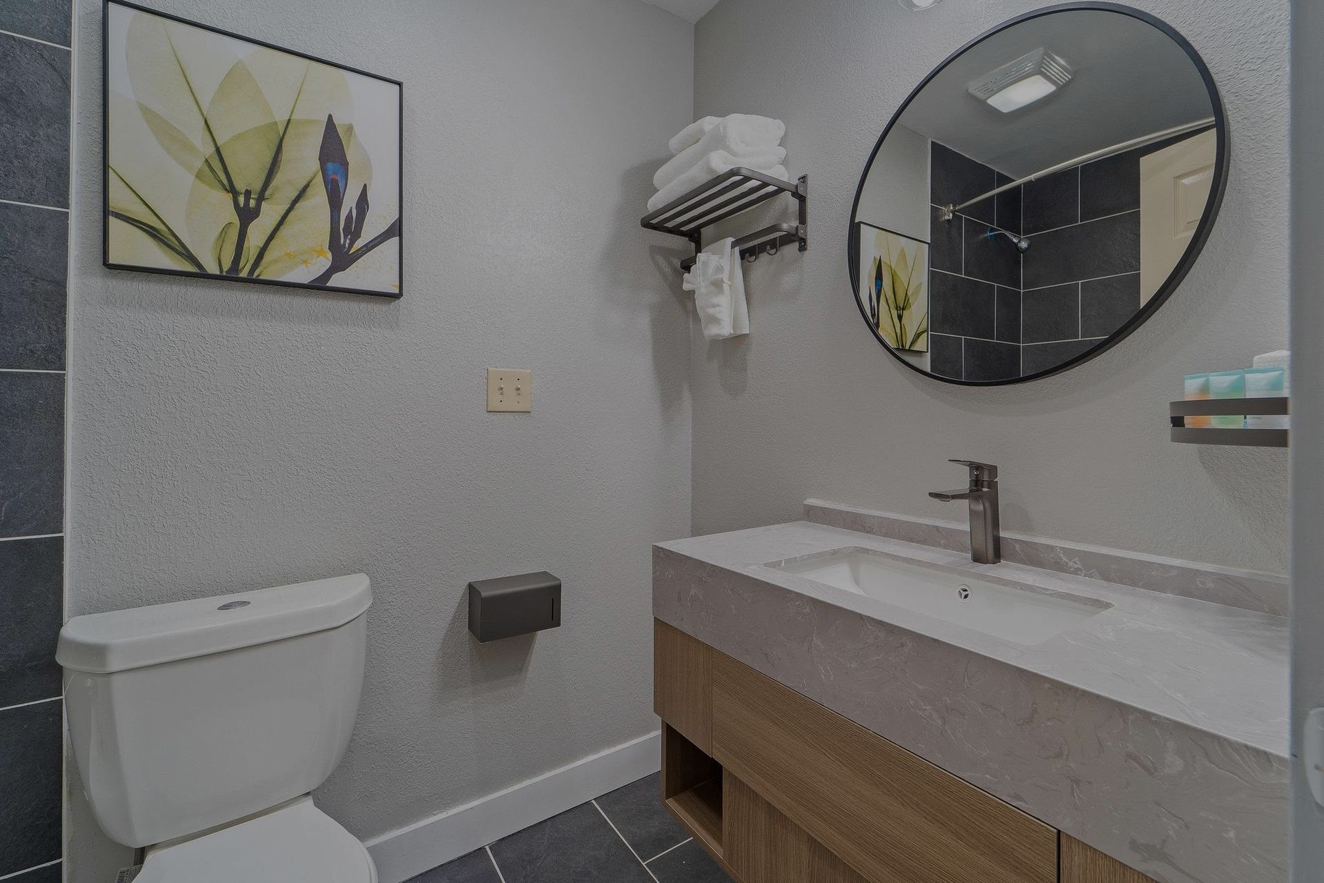 A bathroom with a toilet , sink , and mirror.