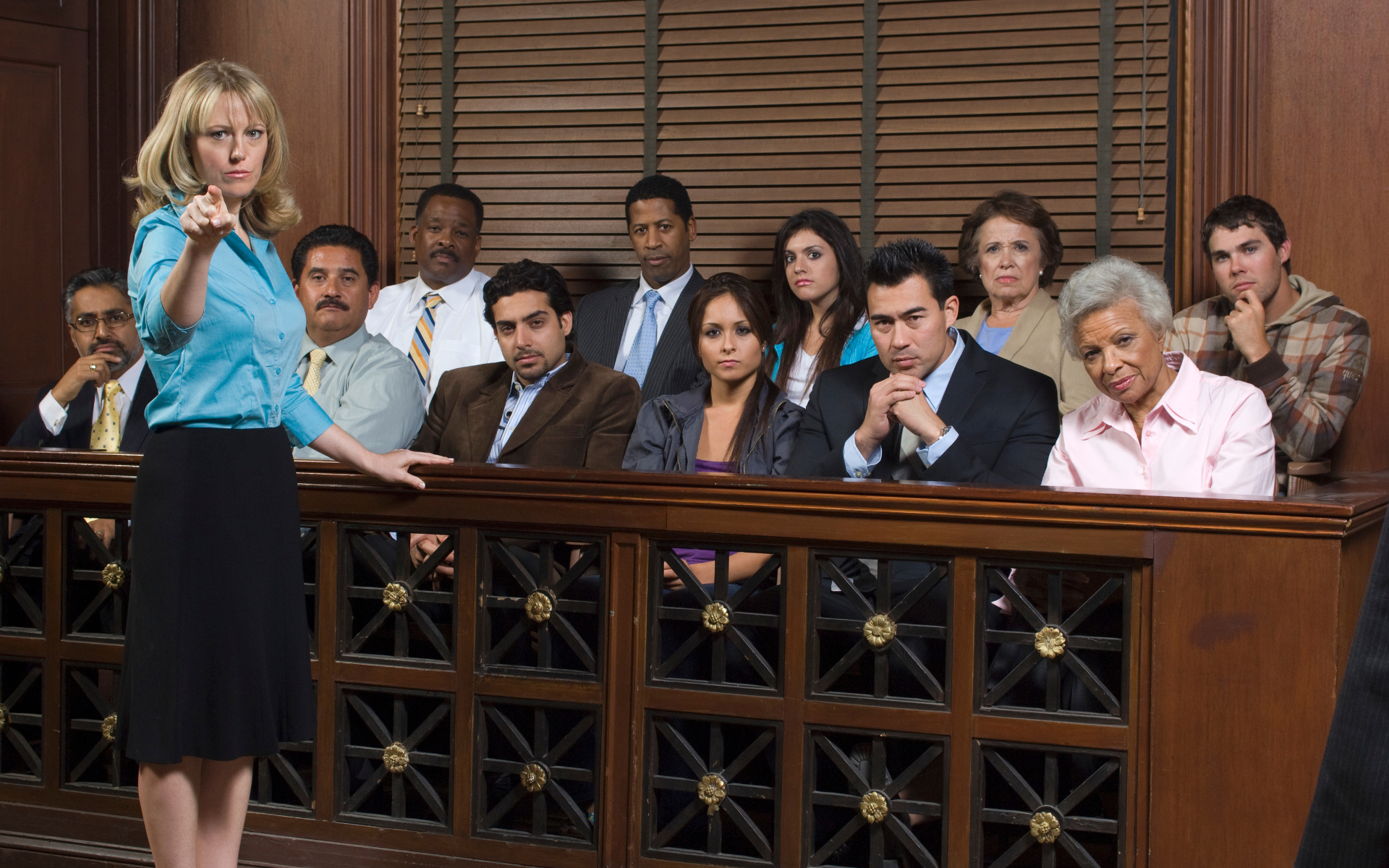 A woman in a courtroom pointing at the jury; diverse individuals seated in the jury box.