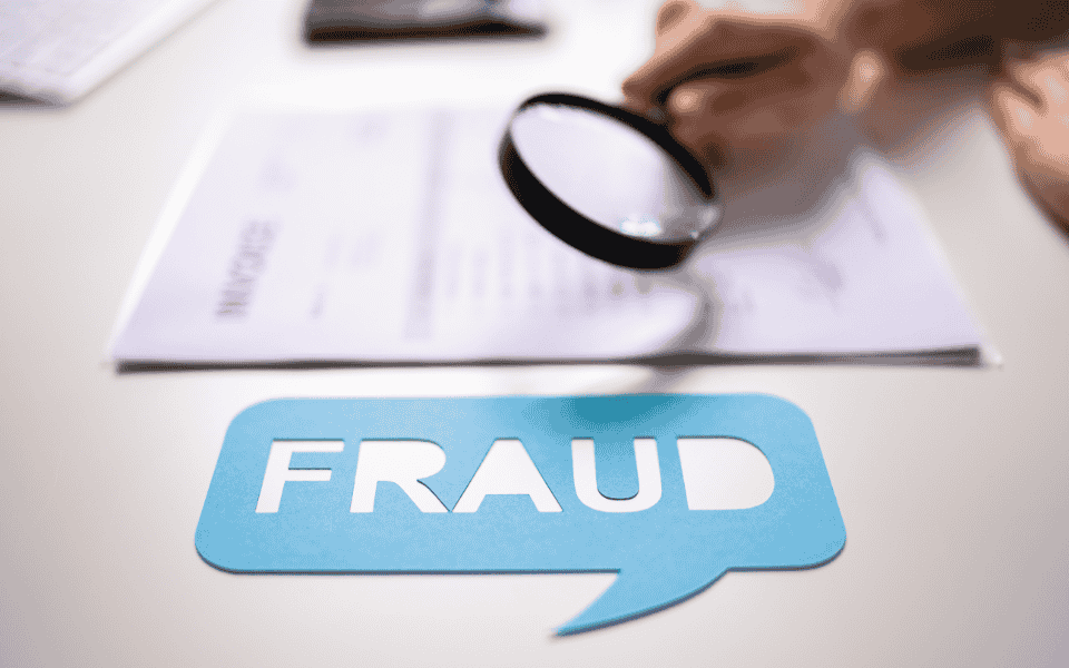 Person using a magnifying glass to examine a document, with a blue