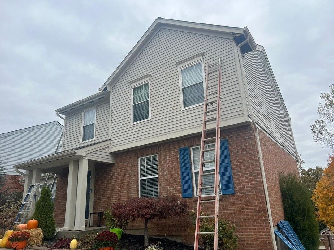A large brick house with a ladder on the side of it.