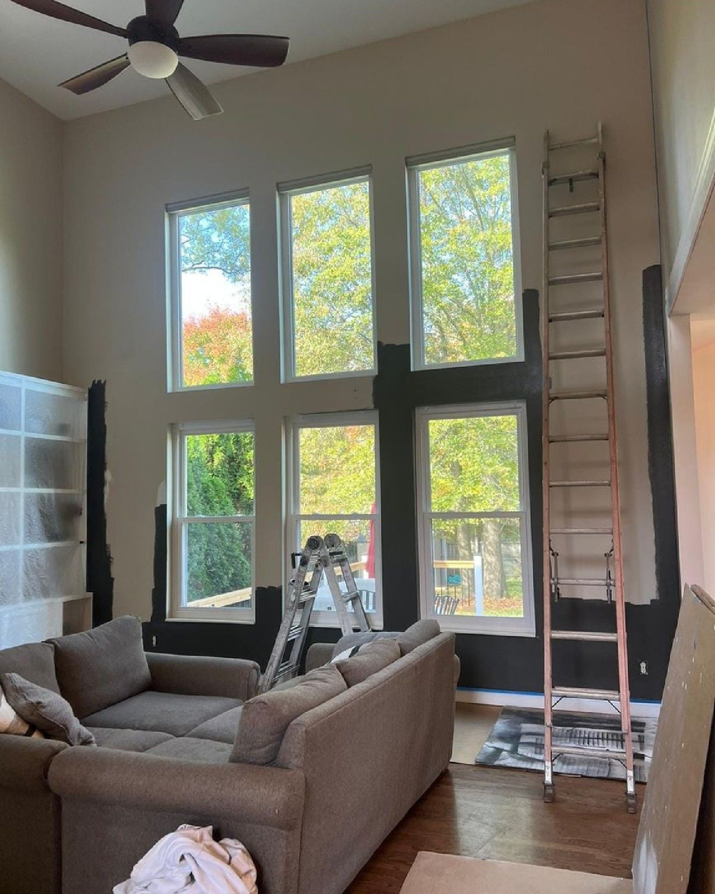 A living room with a couch and a ladder in it