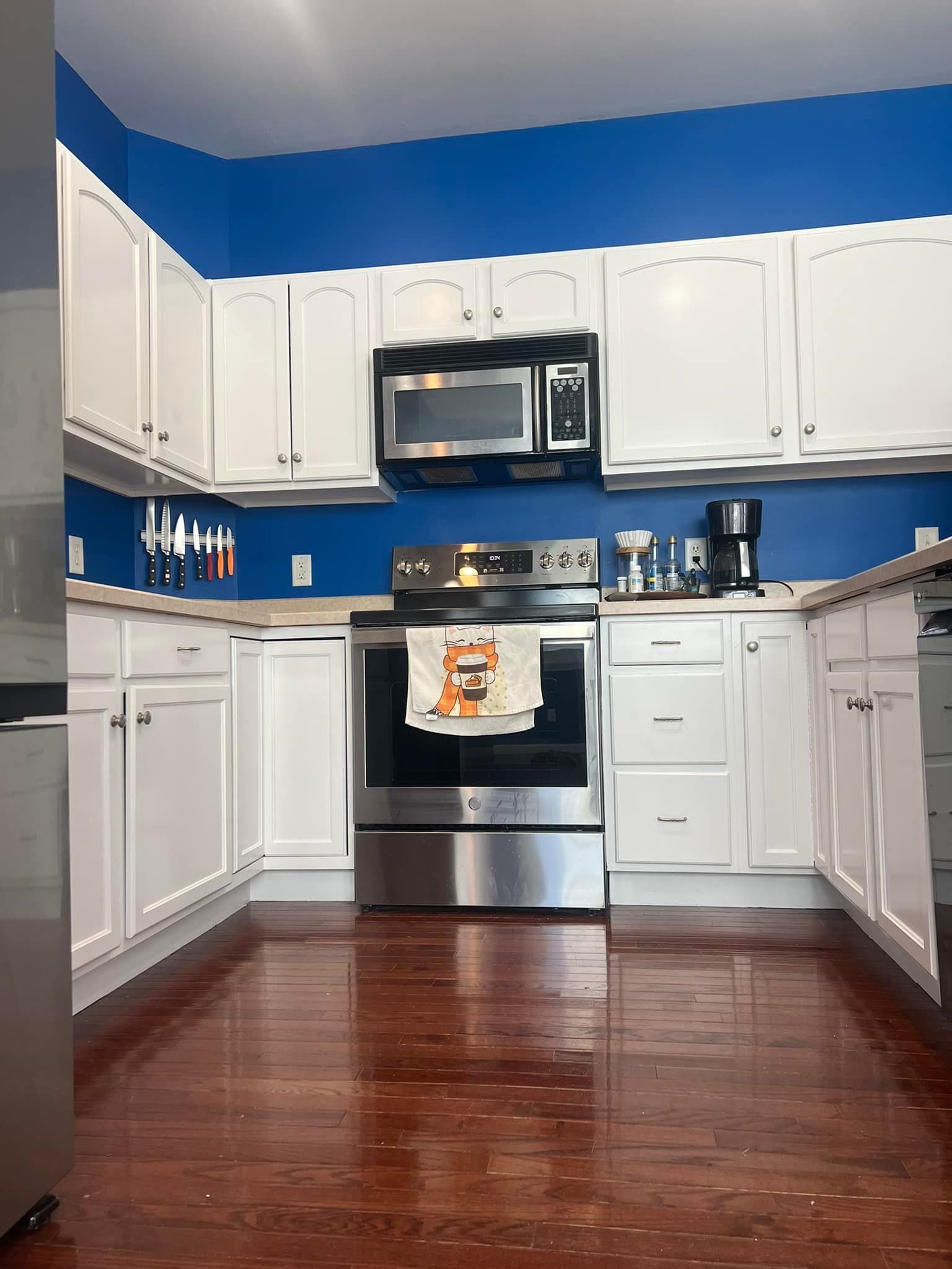 A kitchen with stainless steel appliances and white cabinets