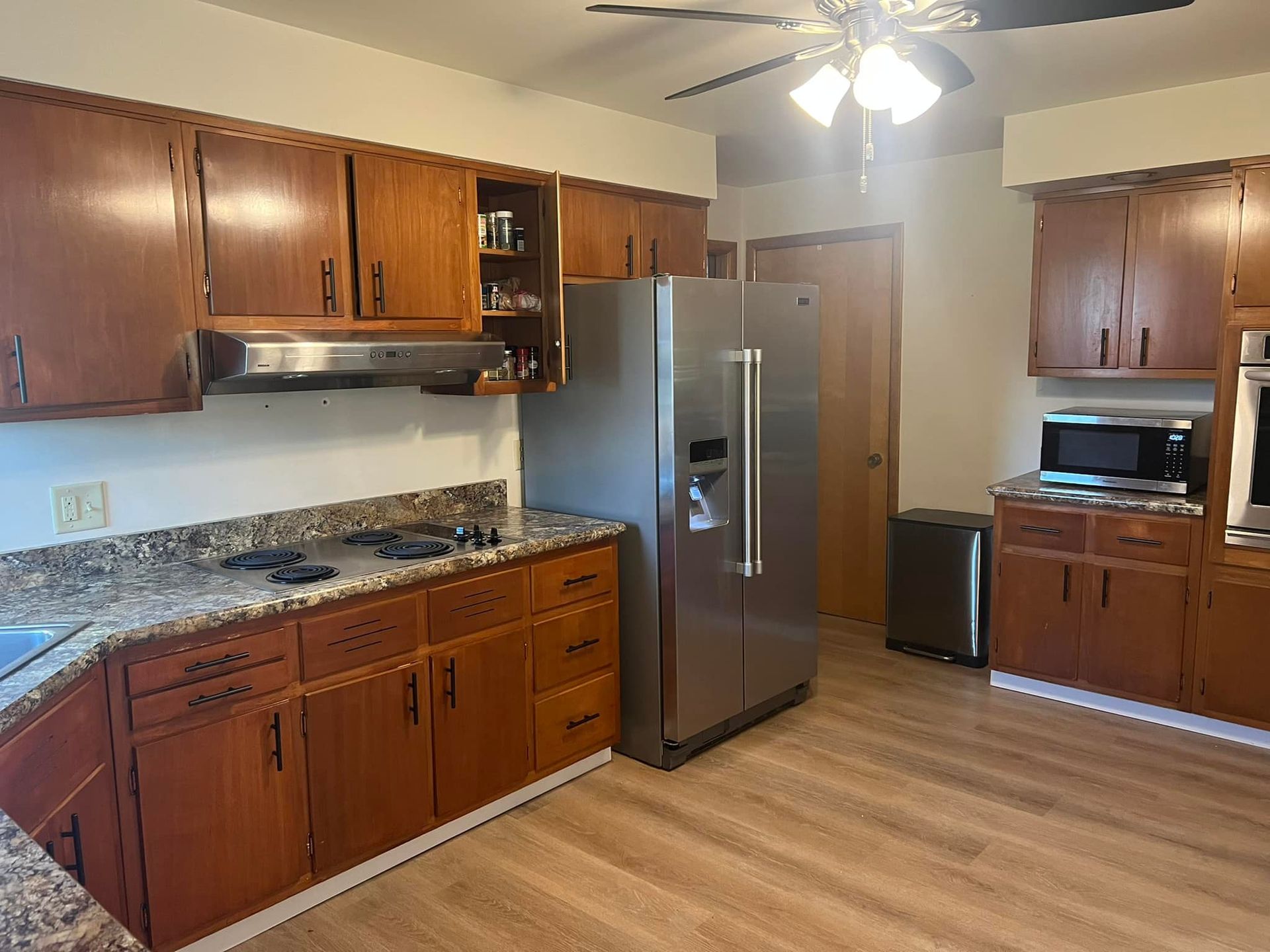A kitchen with stainless steel appliances and wooden cabinets.